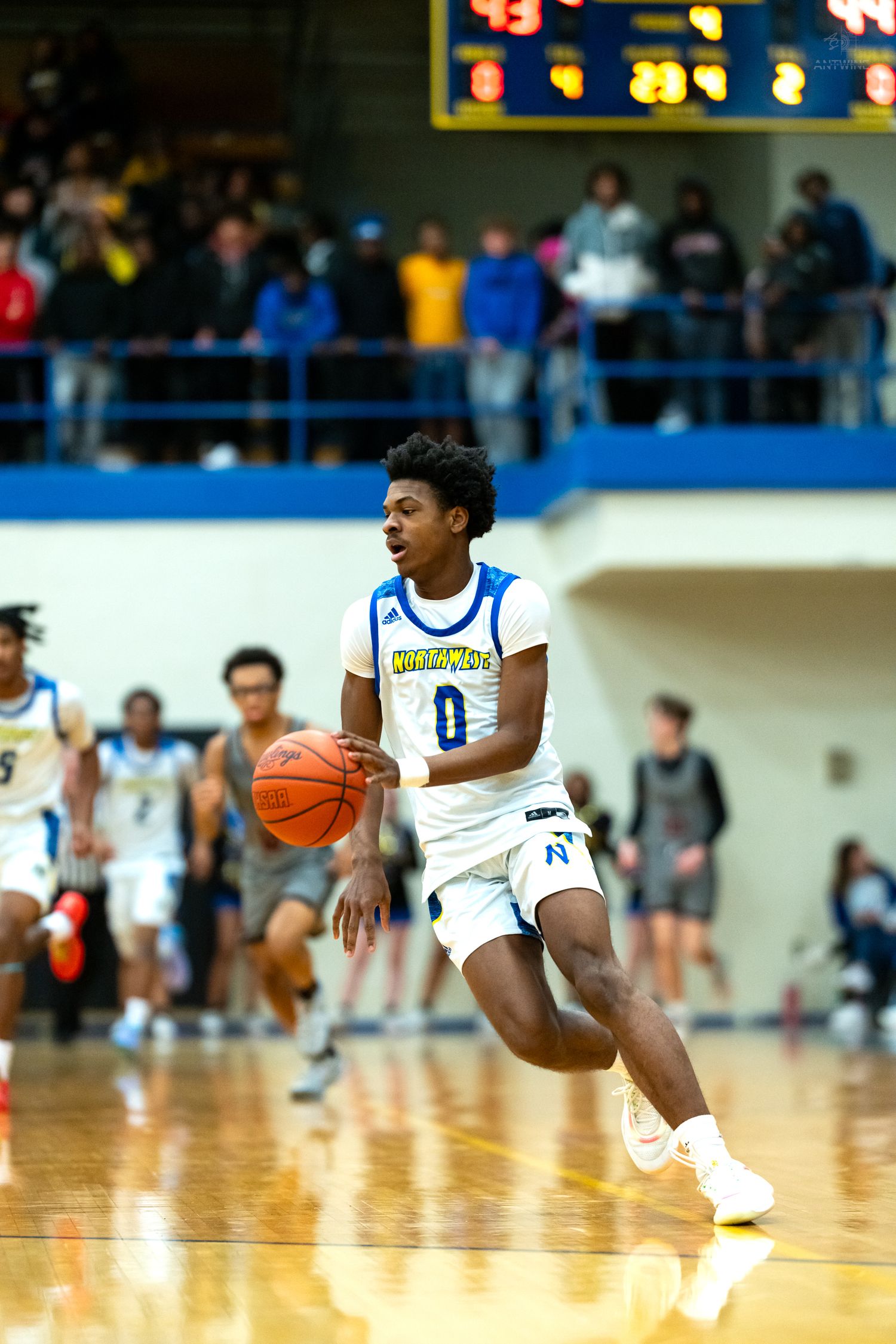 Player #0 in white Northgate uniform dribbles fast break during high school basketball game.