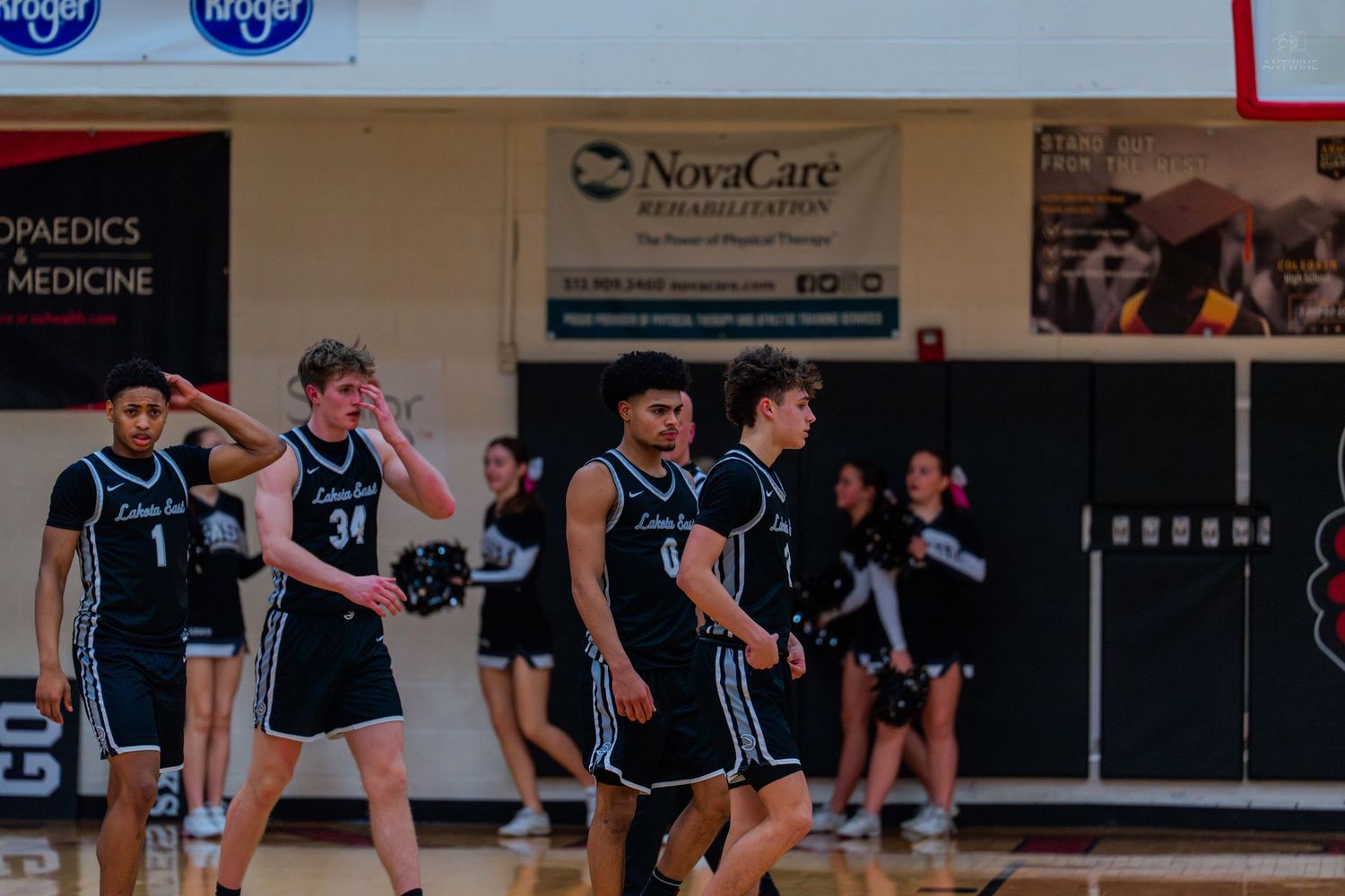Lakota East basketball players walk on court during high school game.