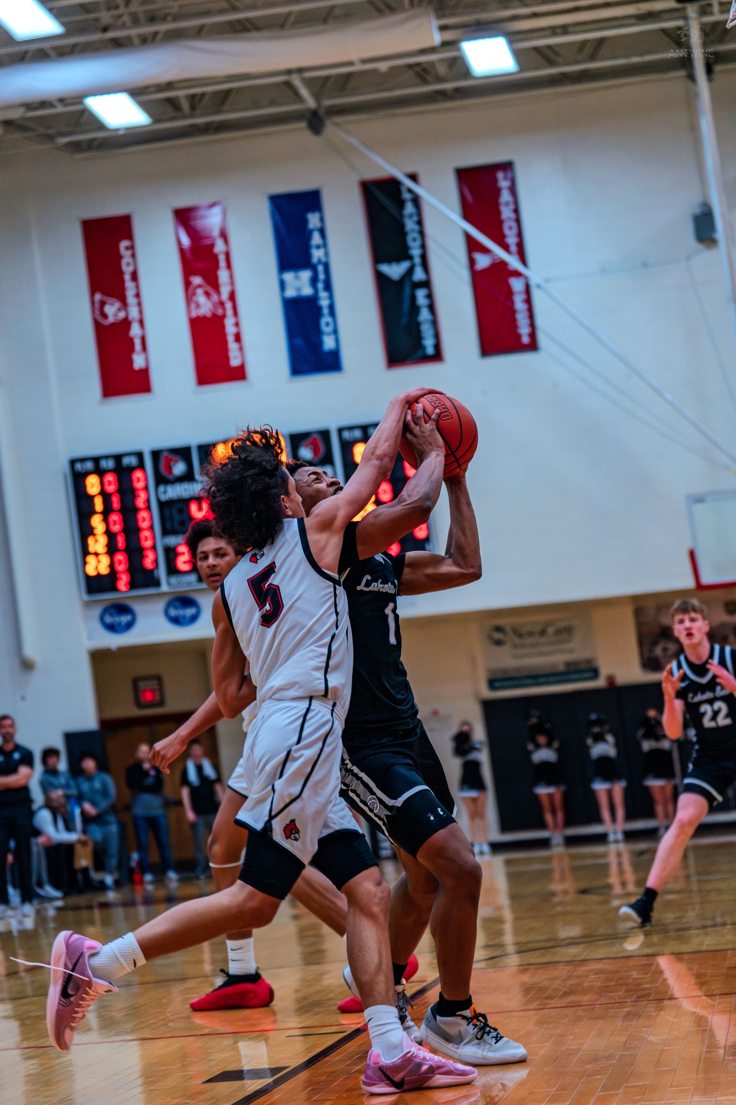 Lakota East player #1 attempts a shot while defended during a high school basketball game.