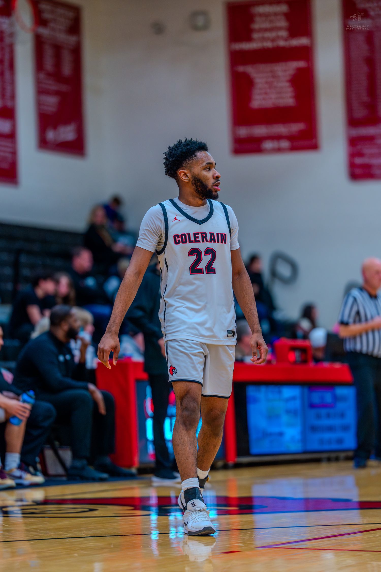 Colerain basketball player #22 walks on the court during a high school game in a white uniform.
