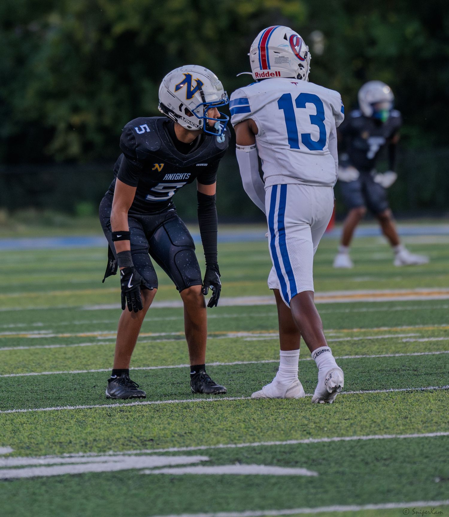 Knights player number 5 in black uniform faces off against opposing player number 13.