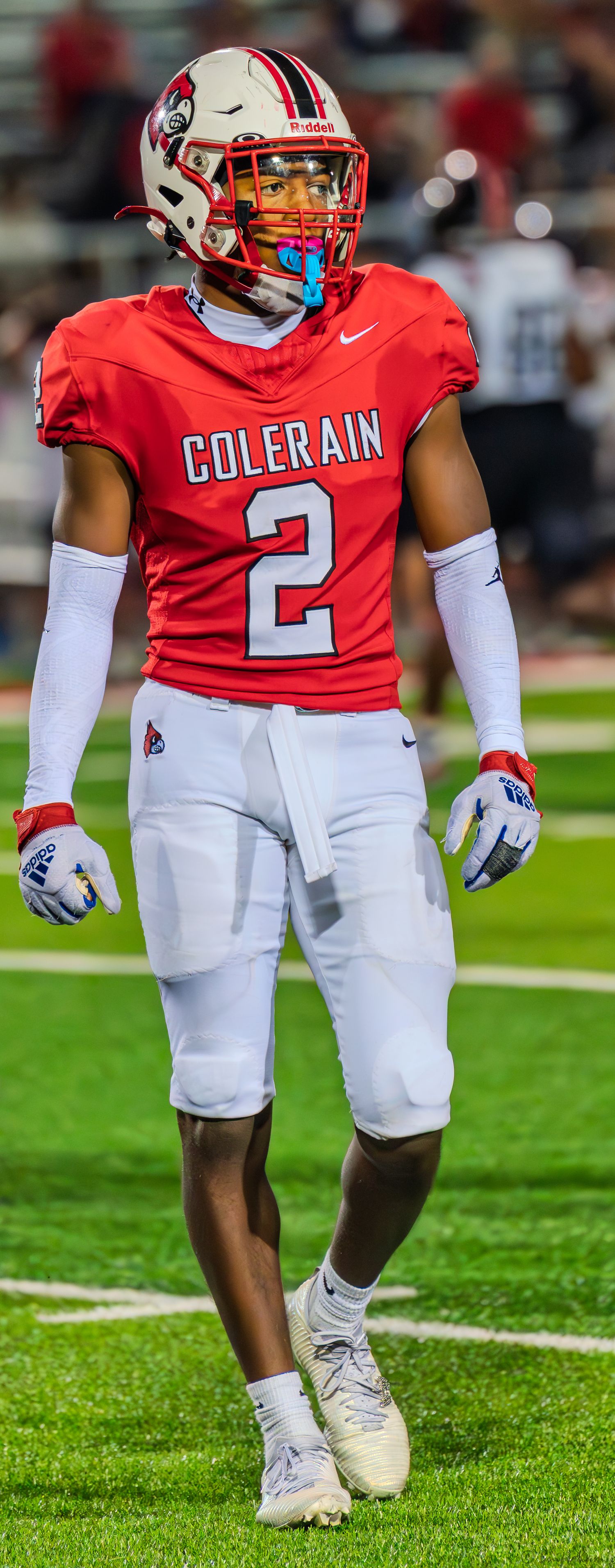 Colerain Cardinals player #2 stands on the field in red uniform during a night football game.