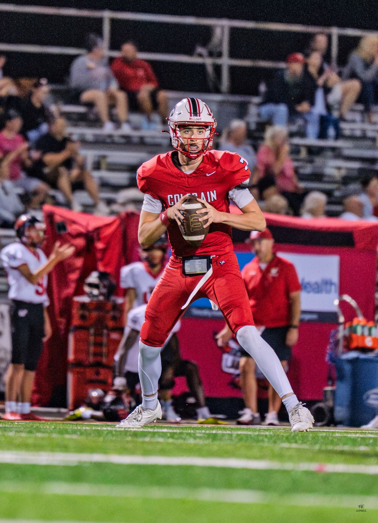 Colerain Cardinals quarterback #7 looks to pass from the pocket during a night game.