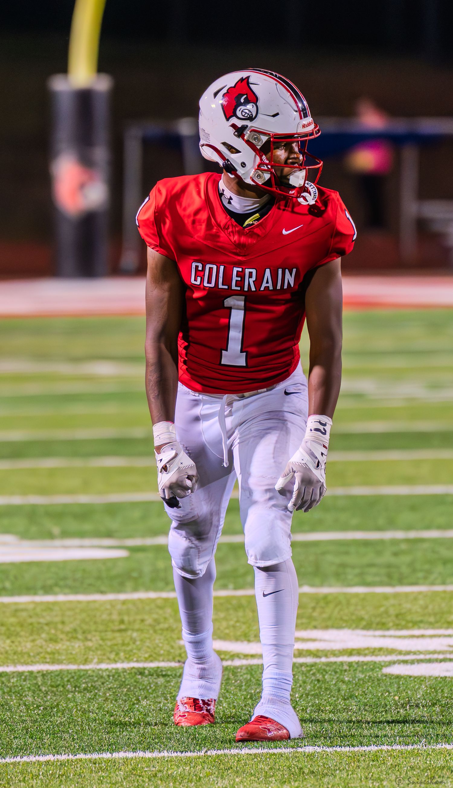 Colerain Cardinals player #1 stands on field in red uniform during a football game.