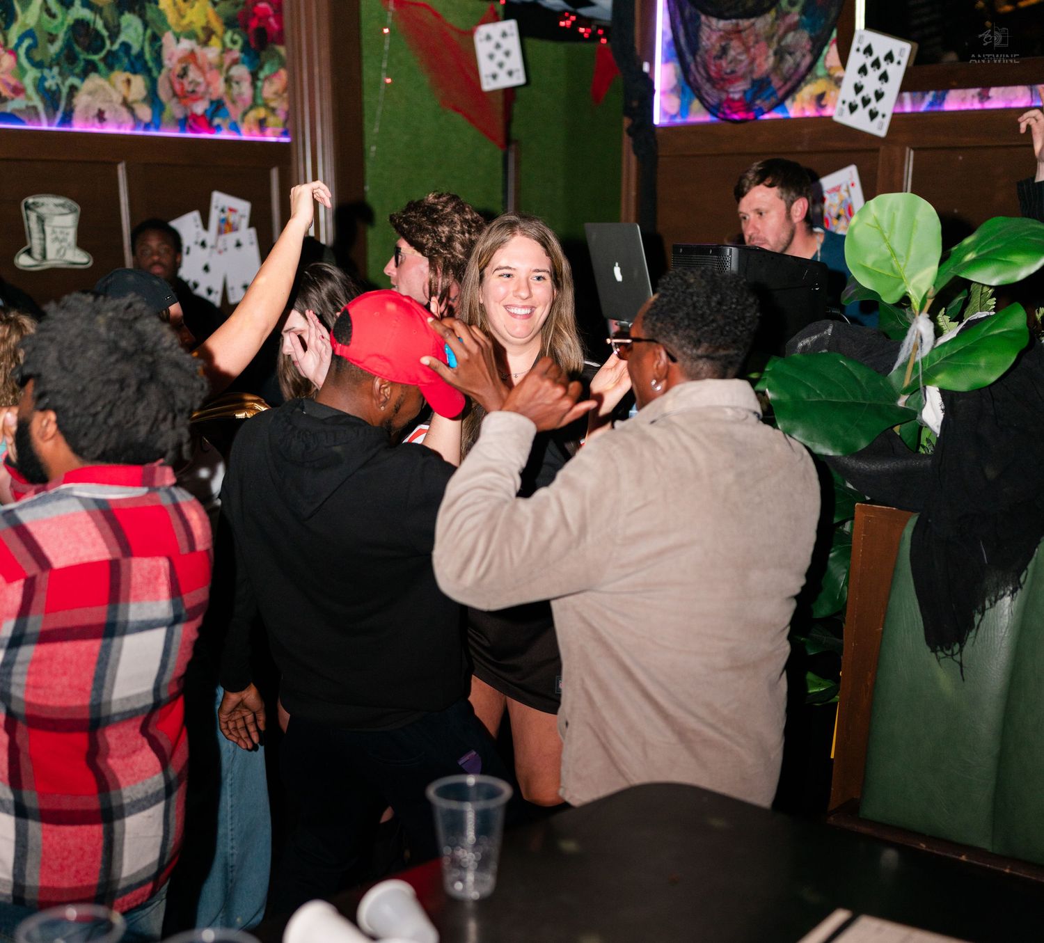 People socializing and dancing at a lively Halloween themed bar event.