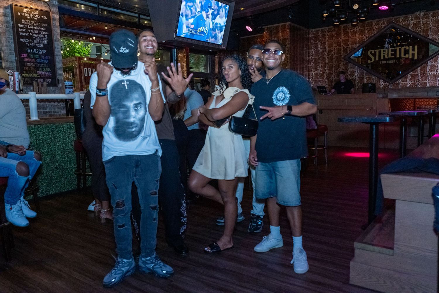 Group of people socializing and gesturing at Stretch Bar during a lively event.