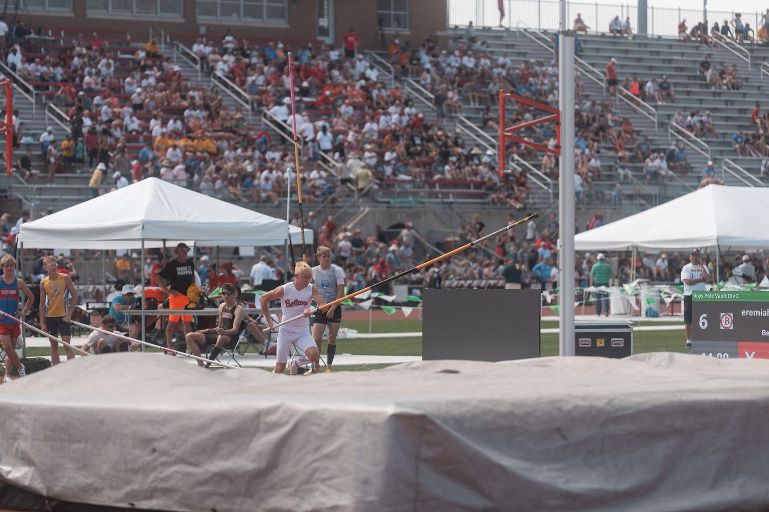 Athlete prepares to throw javelin at a large outdoor track and field stadium competition.