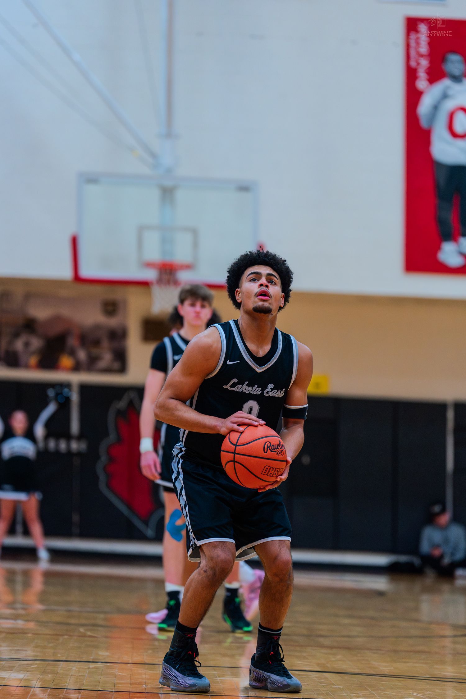 Lakota East player number 0 focuses at the free throw line during a high school basketball game.