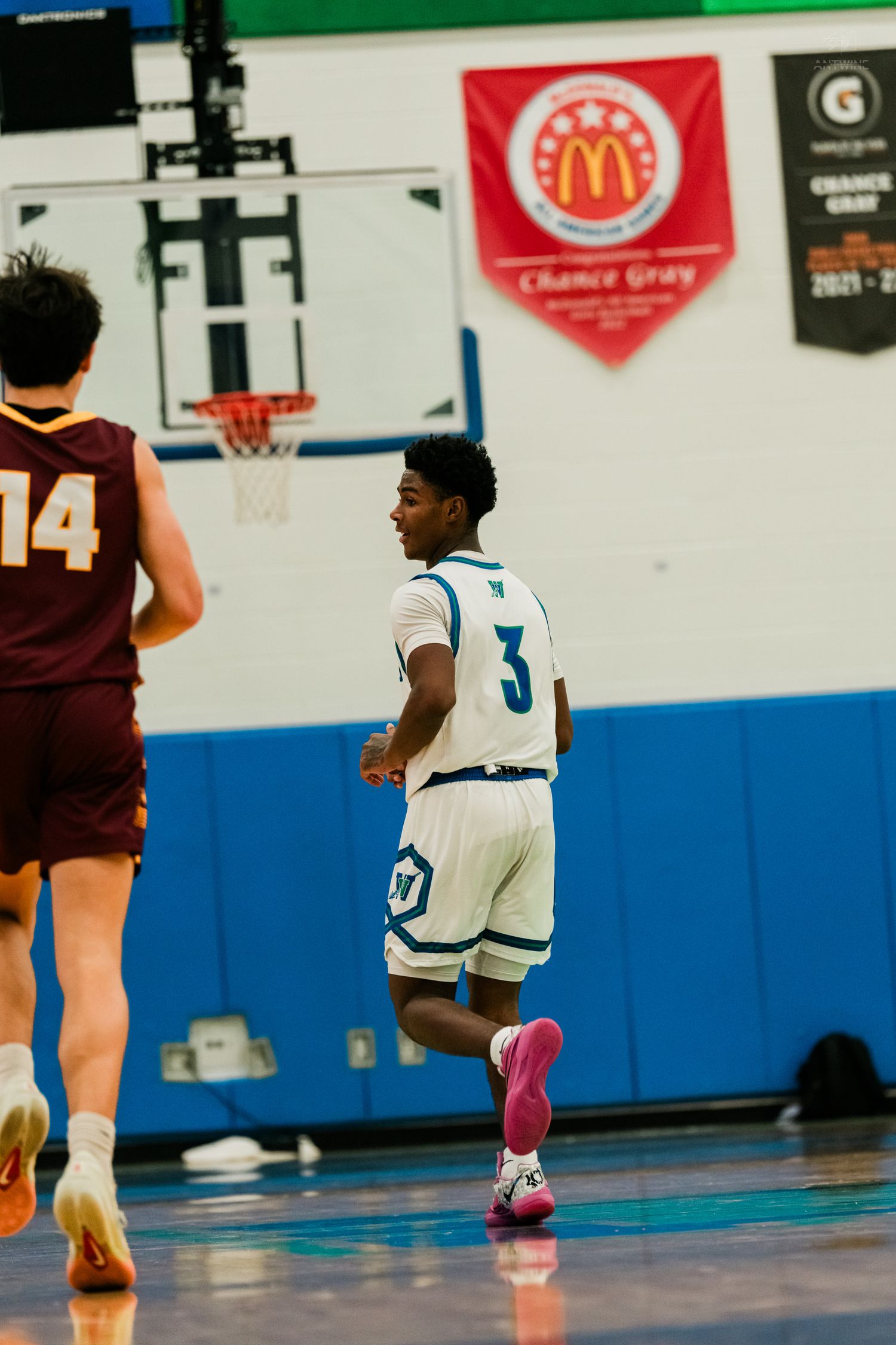 Winton Woods Warriors #3 runs down the court past an opponent during a high school basketball game.