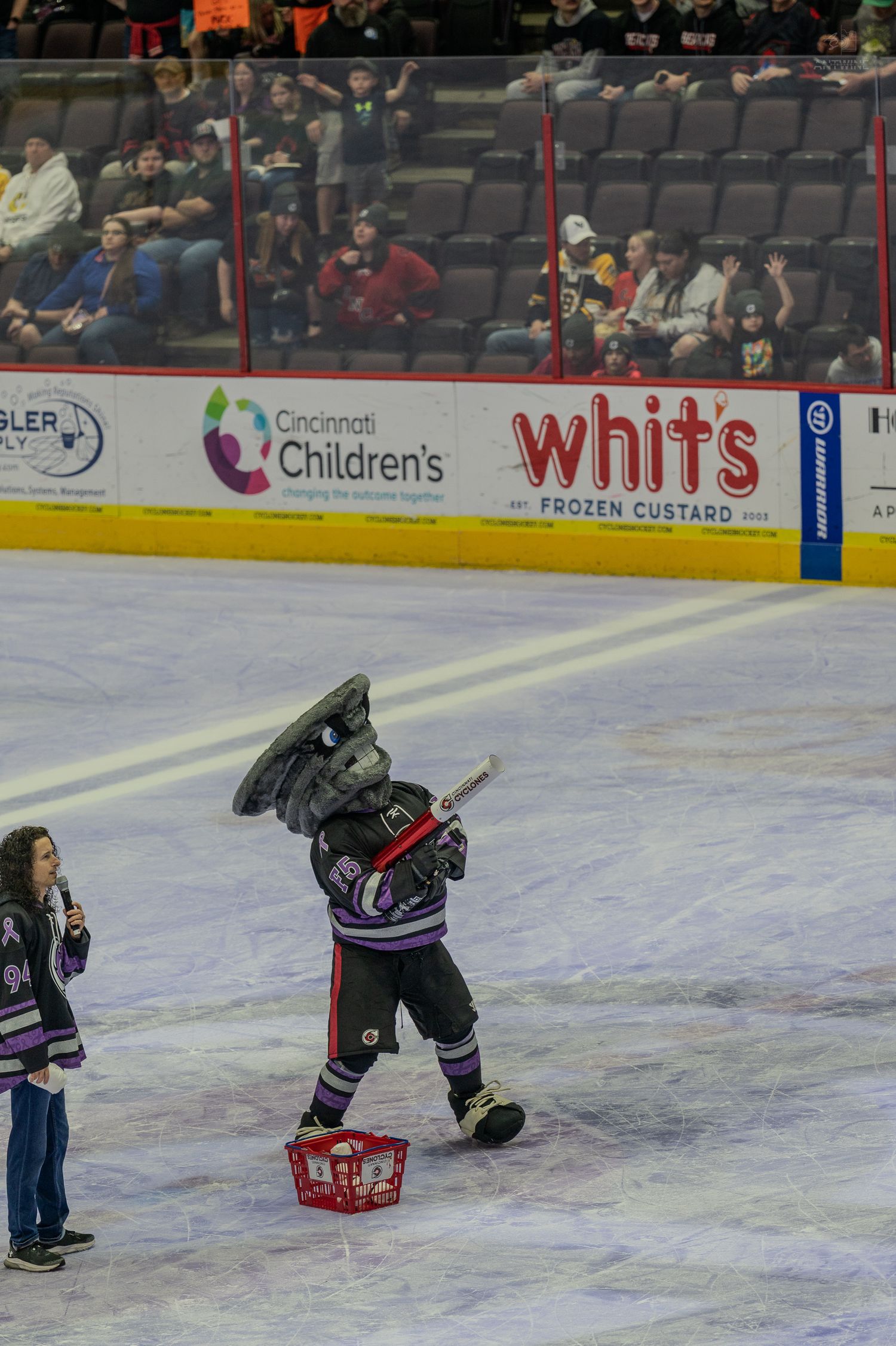 Cincinnati Cyclones mascot performing on ice rink during a live hockey game.
