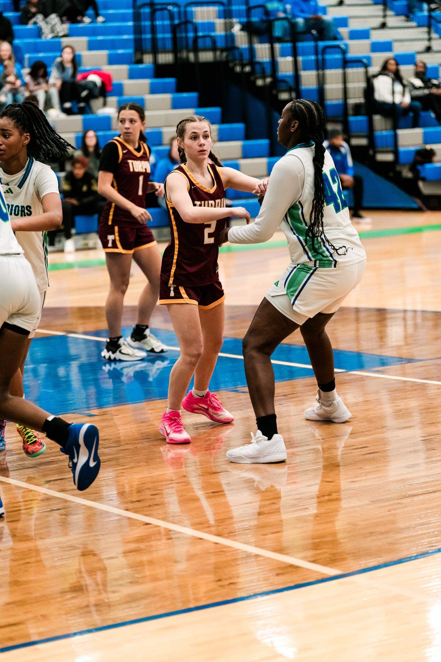 Turpin girls basketball player #2 defends against a Warriors player during a high school game.