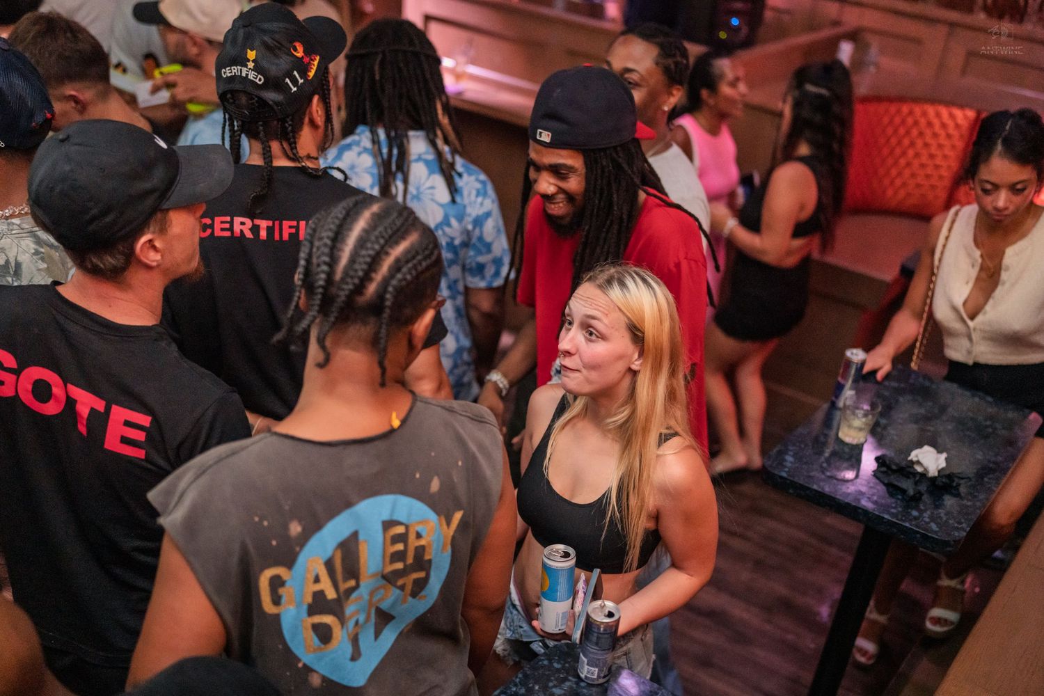 Diverse group of young adults socializing at a lively nightclub party event.