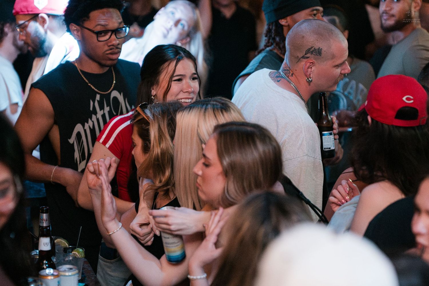 Group of young people socializing and dancing at a vibrant nightclub party.