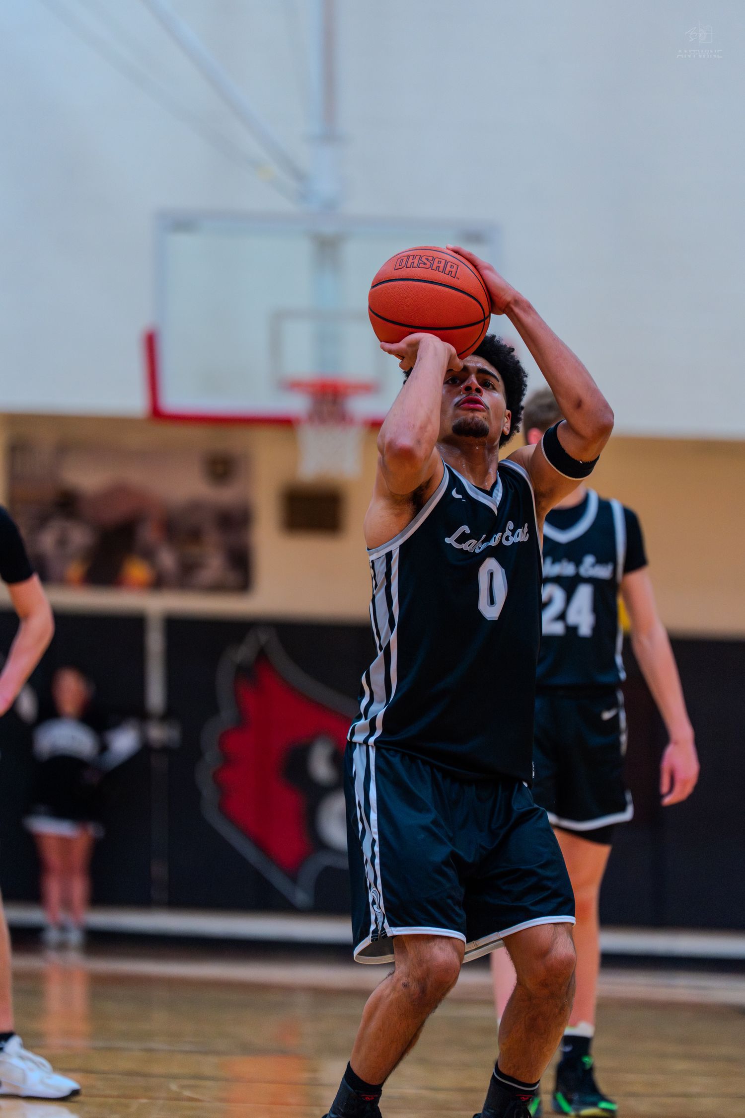 Lakota East player number 0 shoots a free throw during a high school basketball game in a gymnasium.