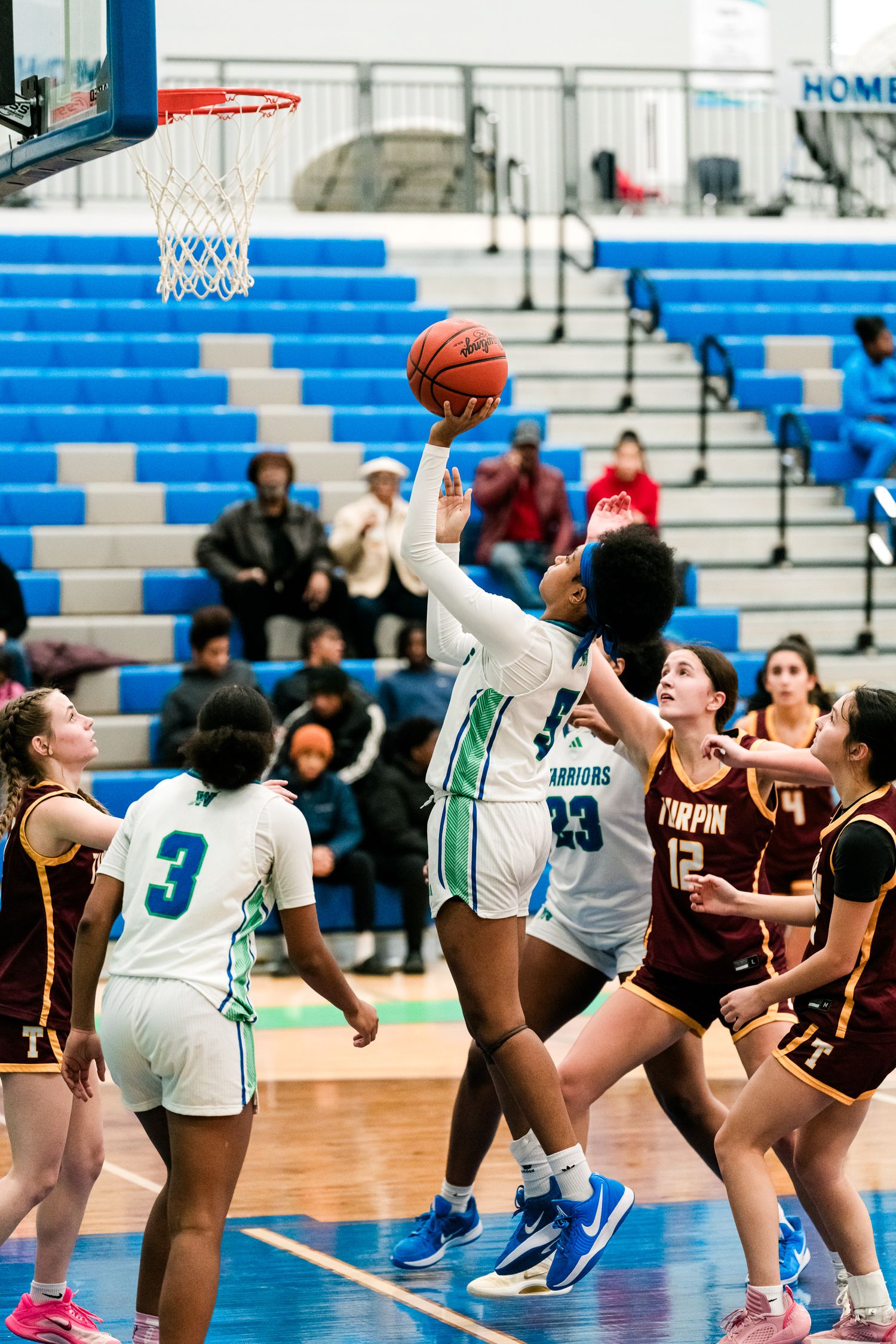 A Winton Woods player number 23 goes up for a layup against Turpin defenders in a girls basketball game.