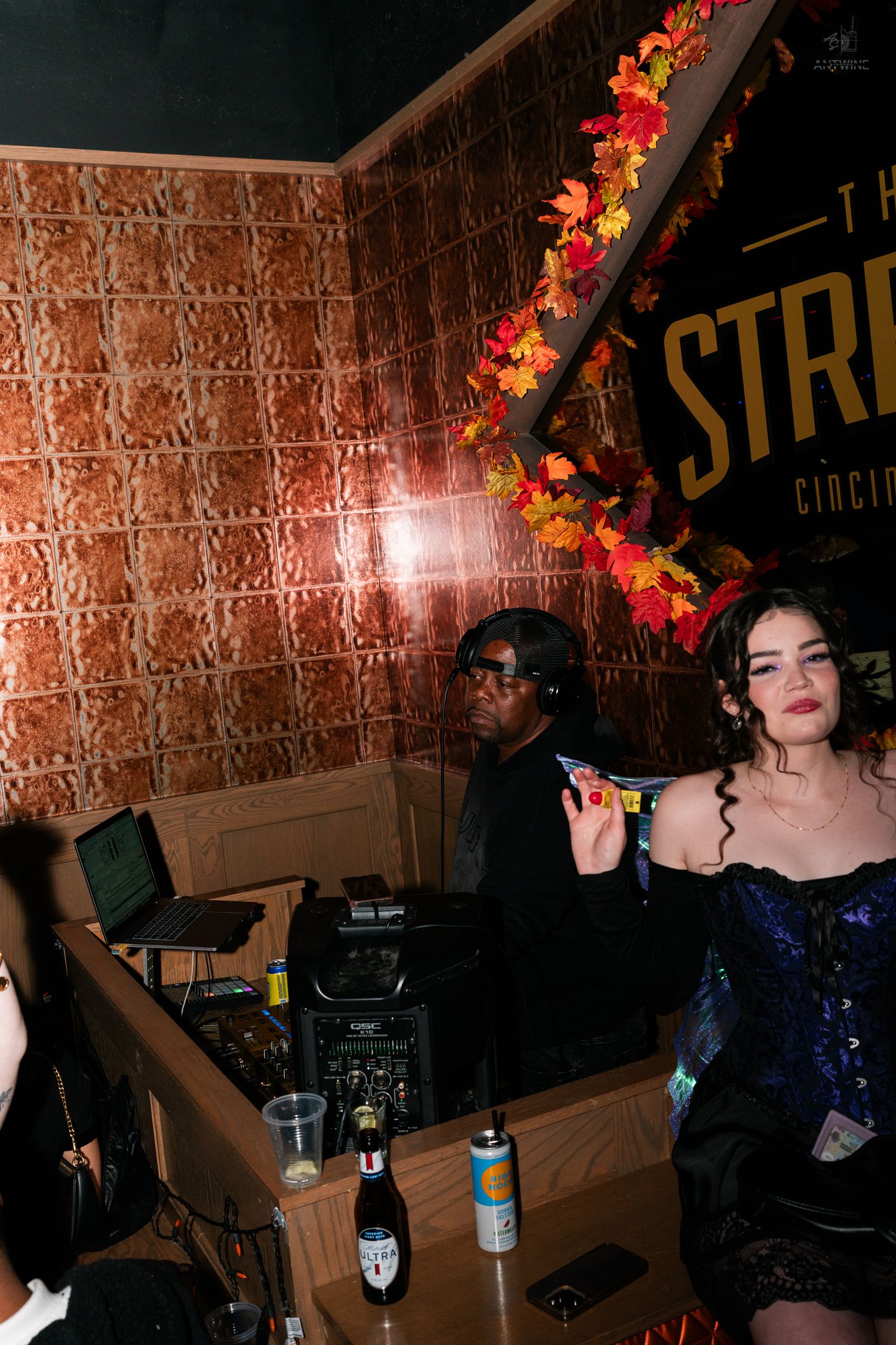 DJ performing at The Stretch Cincinnati bar with woman in blue corset Halloween costume.