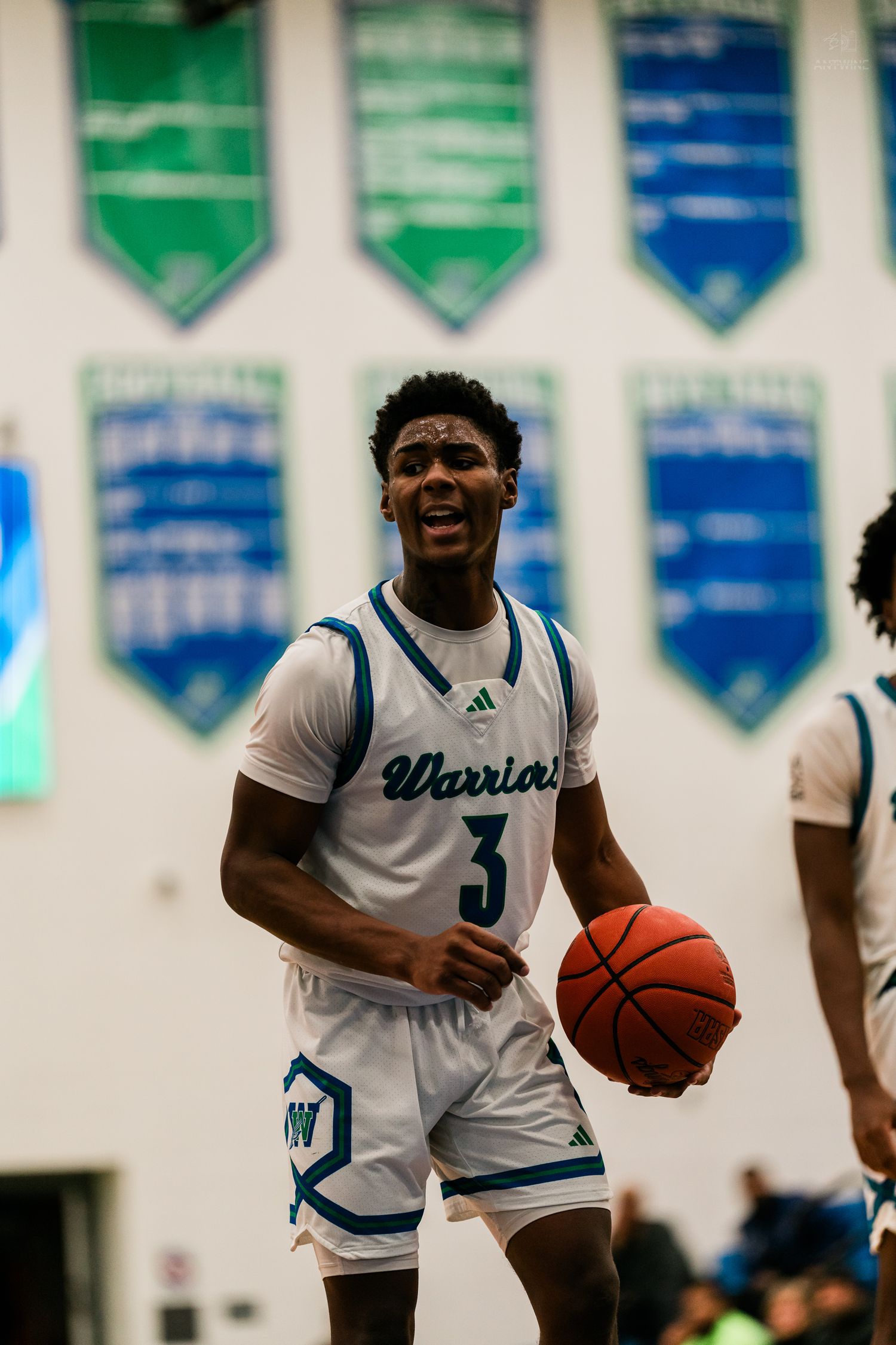 Warriors player #3 dribbles basketball while celebrating during home game.
