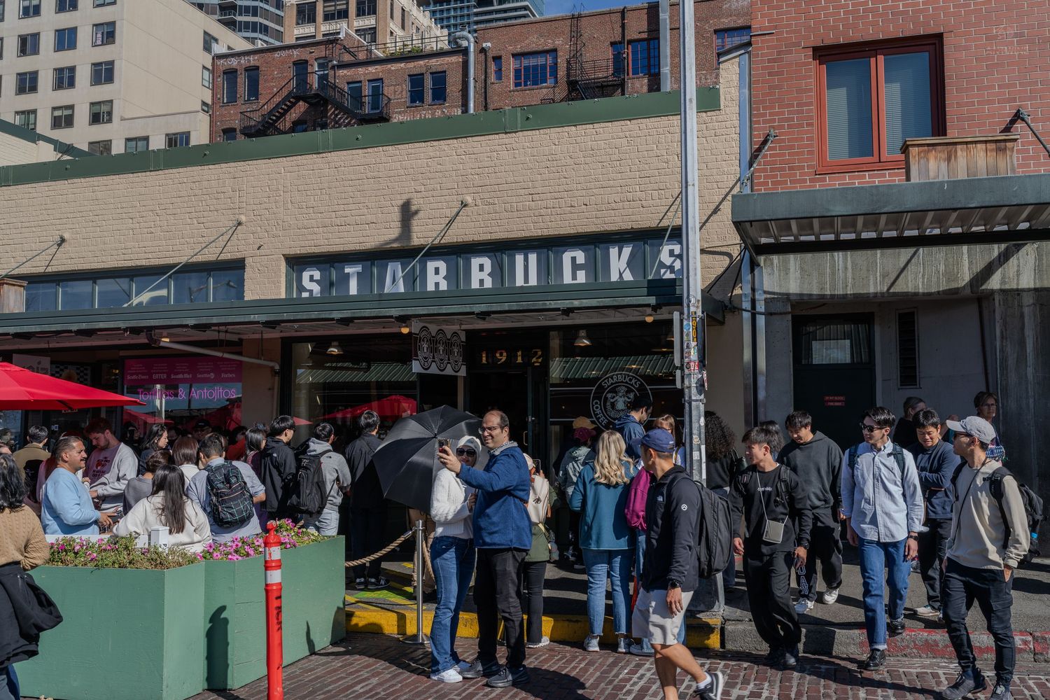 Crowds of tourists gathered outside the original Starbucks store at Pike Place Market in Seattle, Washington.