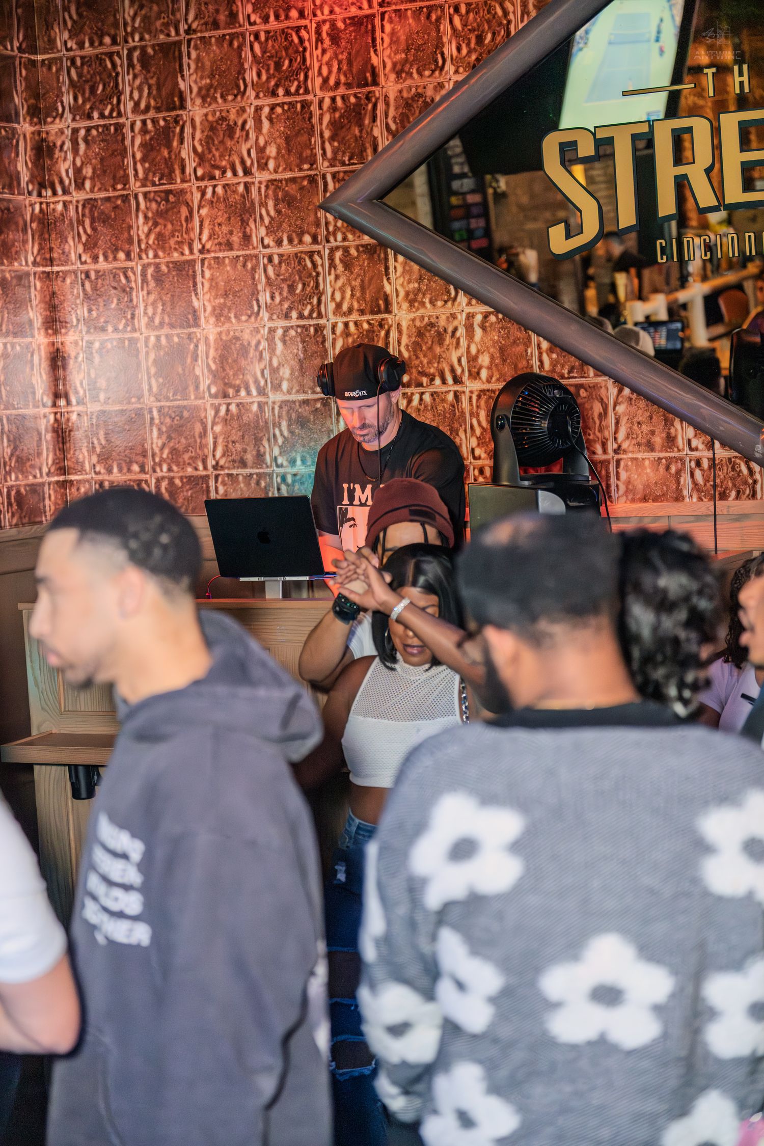 DJ performing at The Street Cincinnati venue while guests dance on the floor.