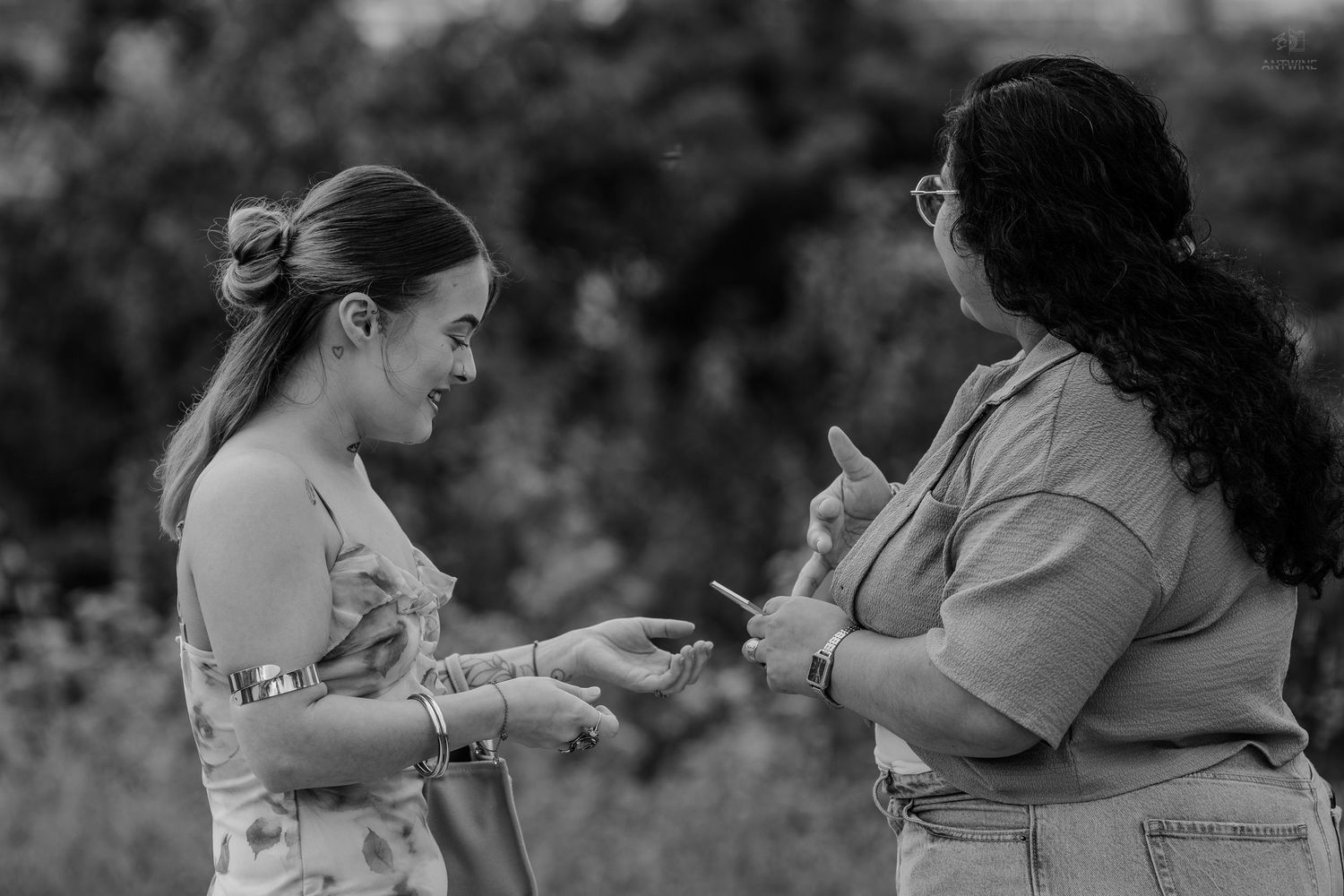 Two women sharing a joyful moment outdoors in black and white photography.