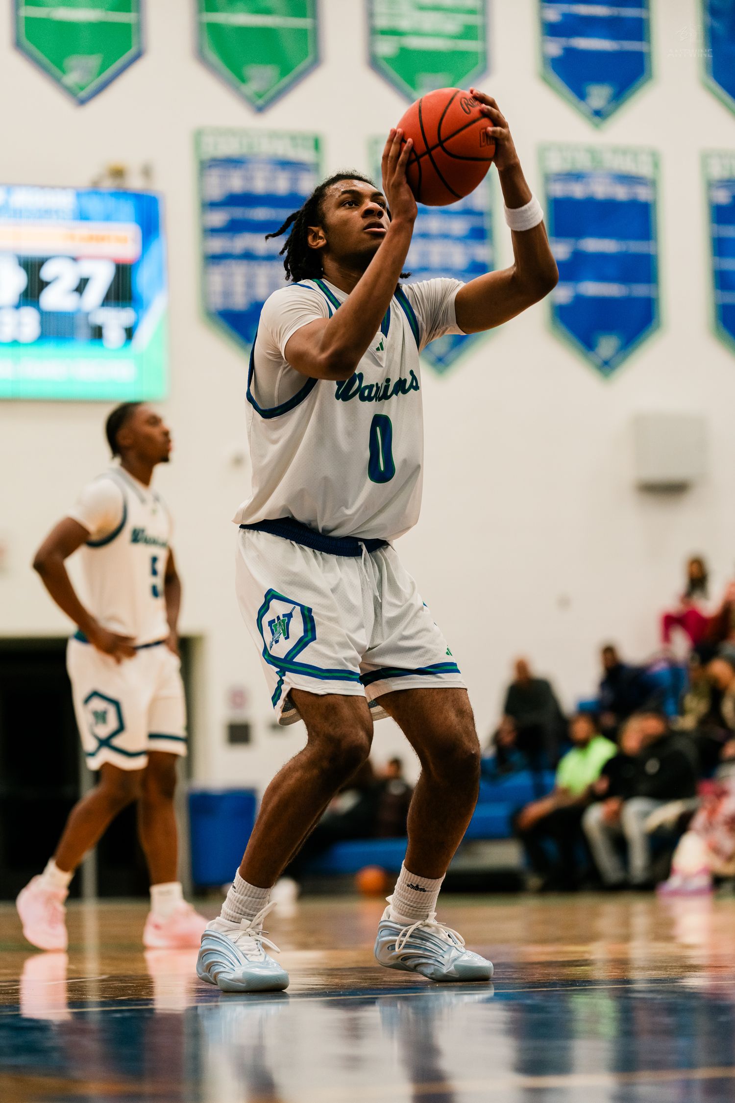 Player #0 in white Warriors uniform shoots basketball during indoor high school game.