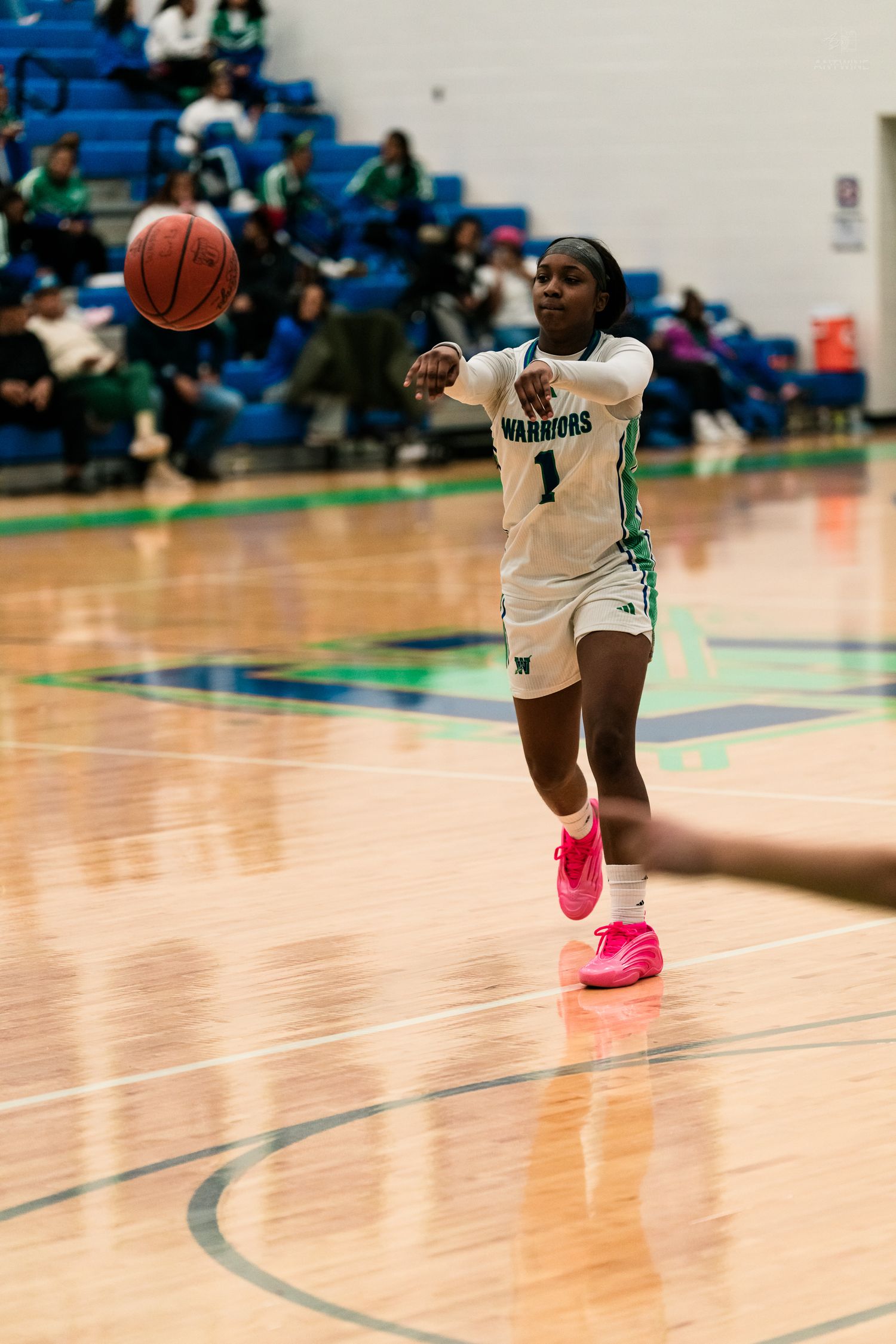 A Warriors girls basketball player wearing number 1 makes a chest pass during a high school basketball game.