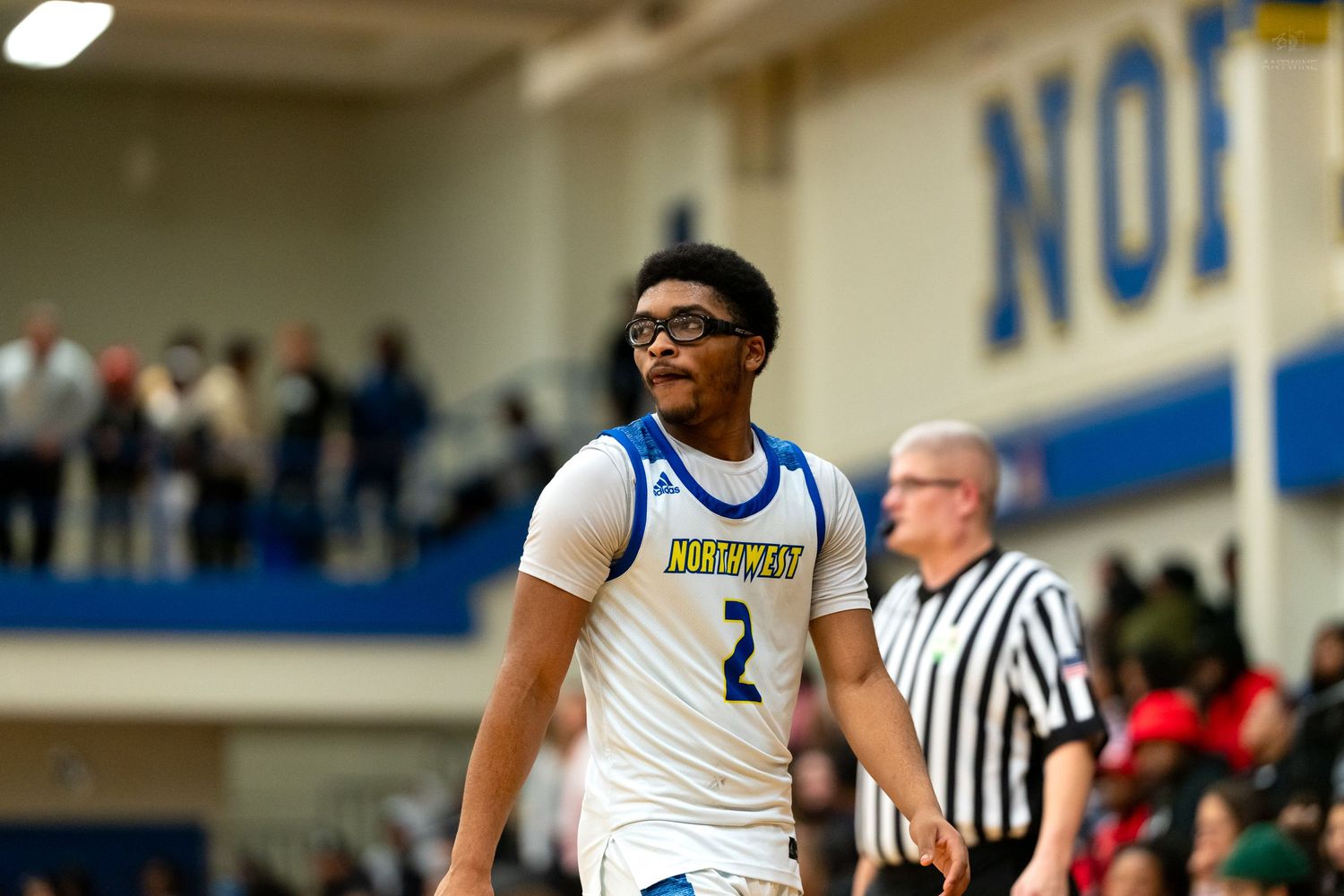 Basketball player number 2 in blue Northwest jersey reacts during a high school game.