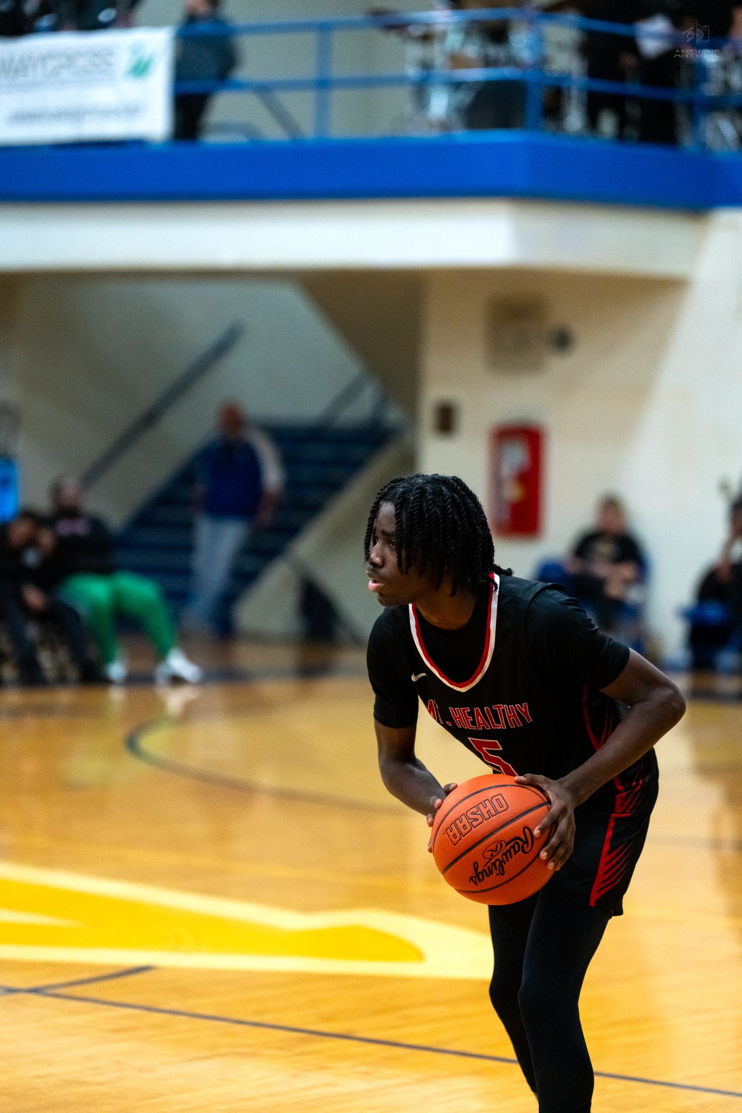 Mt. Healthy player #5 dribbles basketball during high school game.
