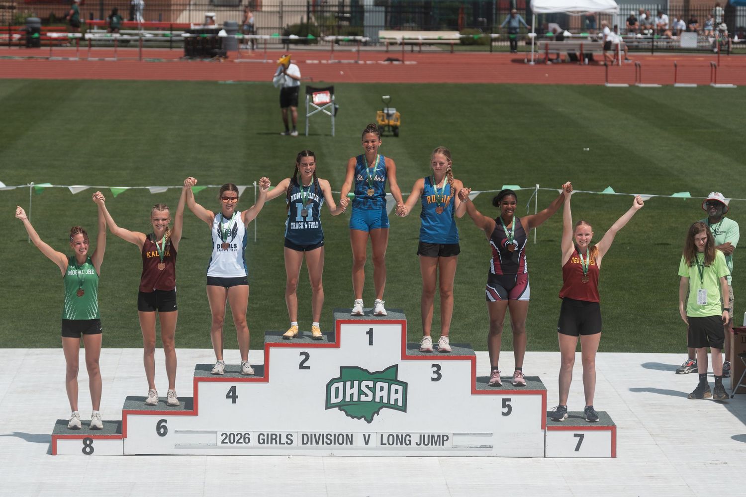 Seven girls pose on numbered places 1-7 at OHSAA 2026 Girls Division V Long Jump awards.