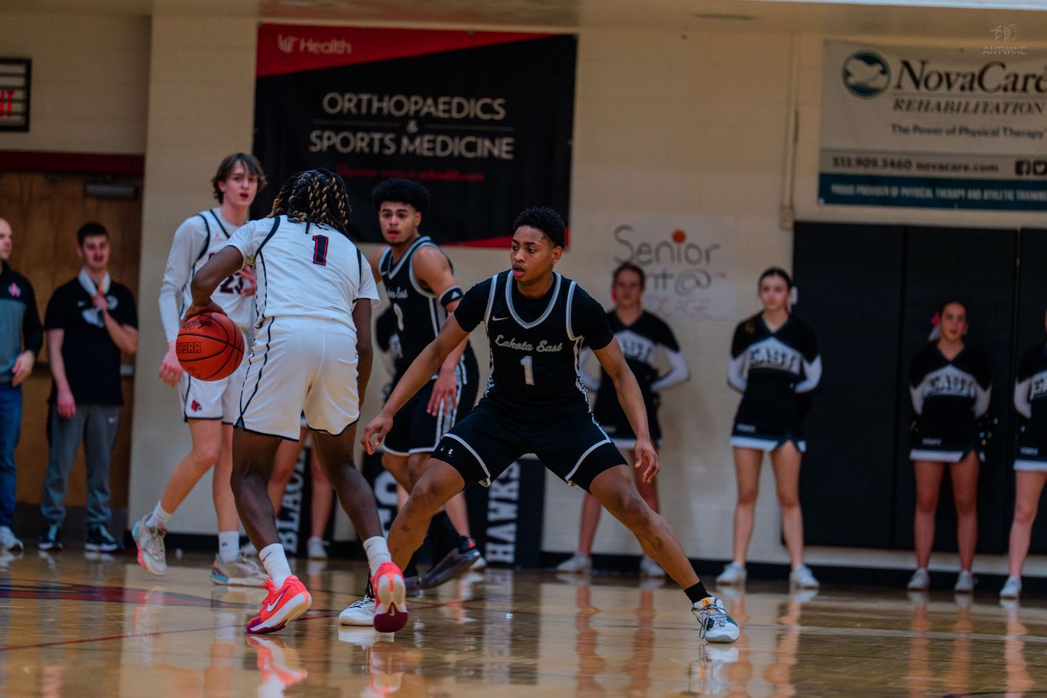 Colerain Cardinals basketball player dribbles while being defended during a home high school basketball game.