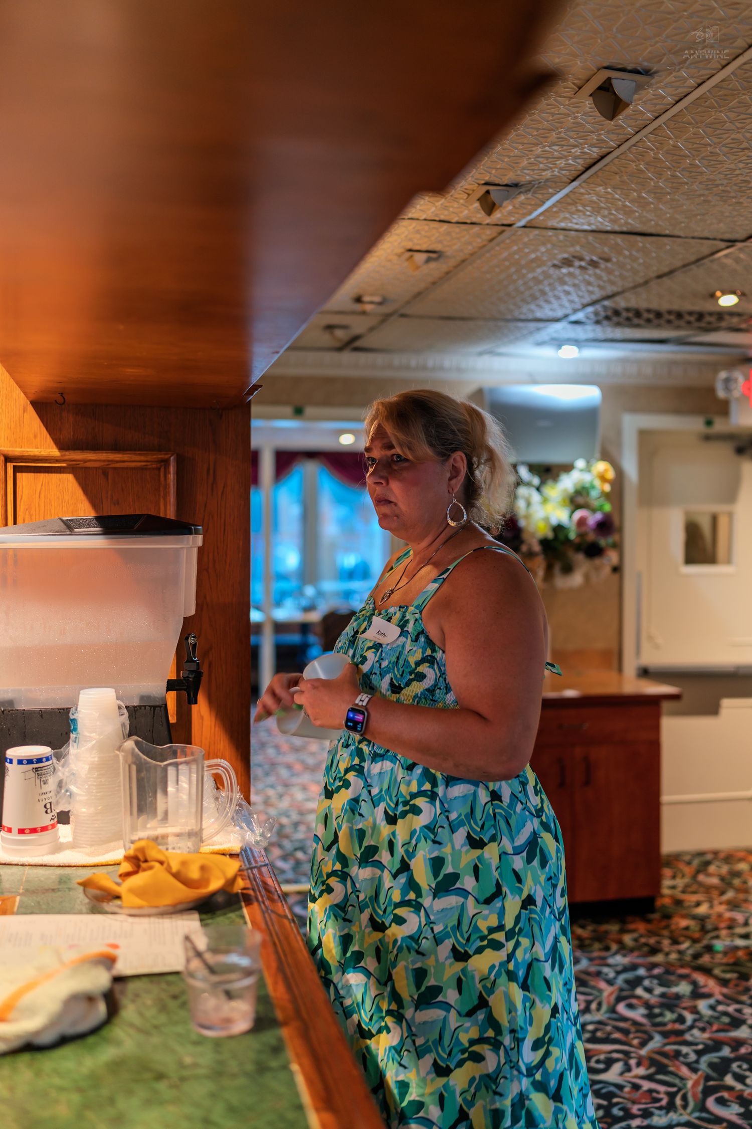 Woman in floral dress standing at a buffet counter inside a elegantly decorated dining room on a cruise ship.