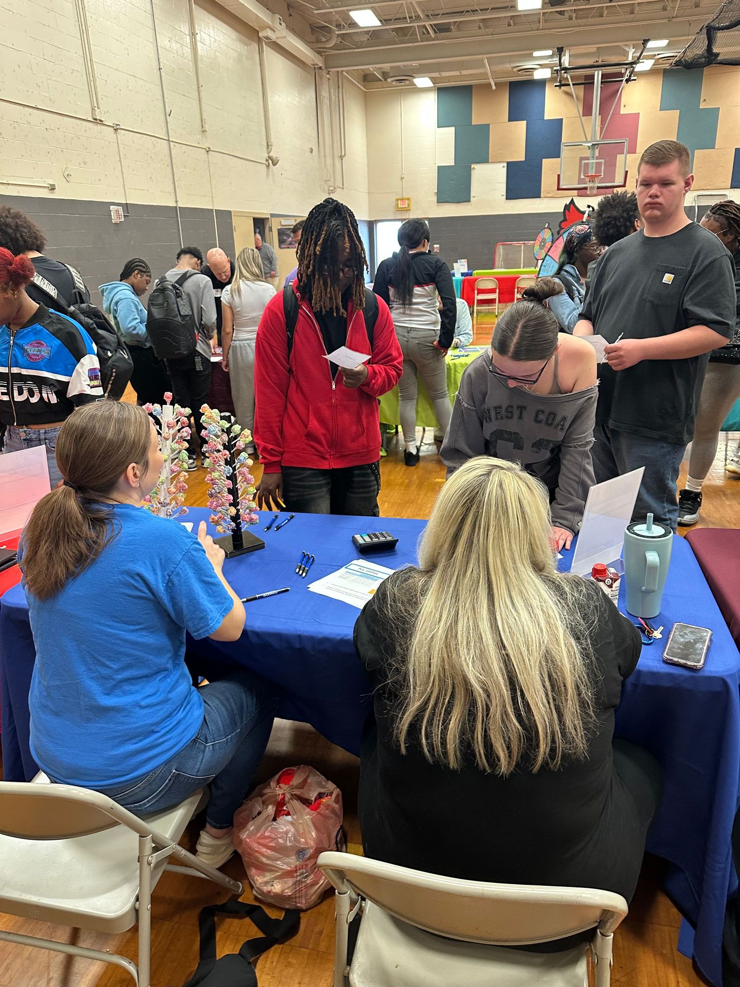 Students and community members gather at informational tables during a Colerain Township school gymnasium resource fair.