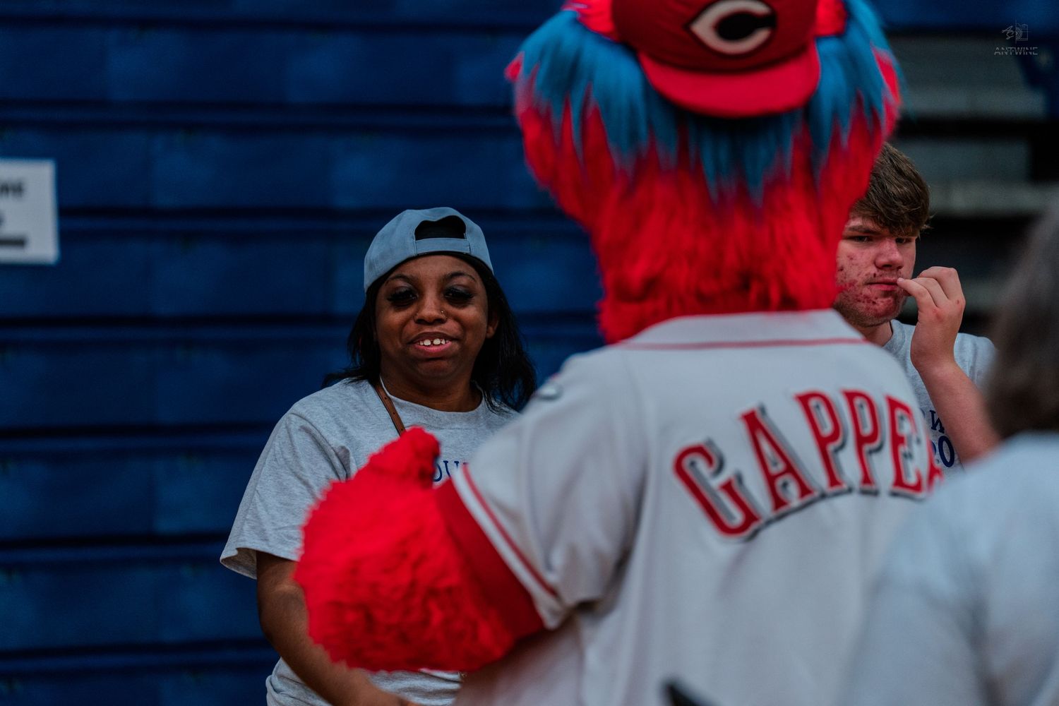 Gapper mascot of Cincinnati Reds interacts with fans at a baseball game event.