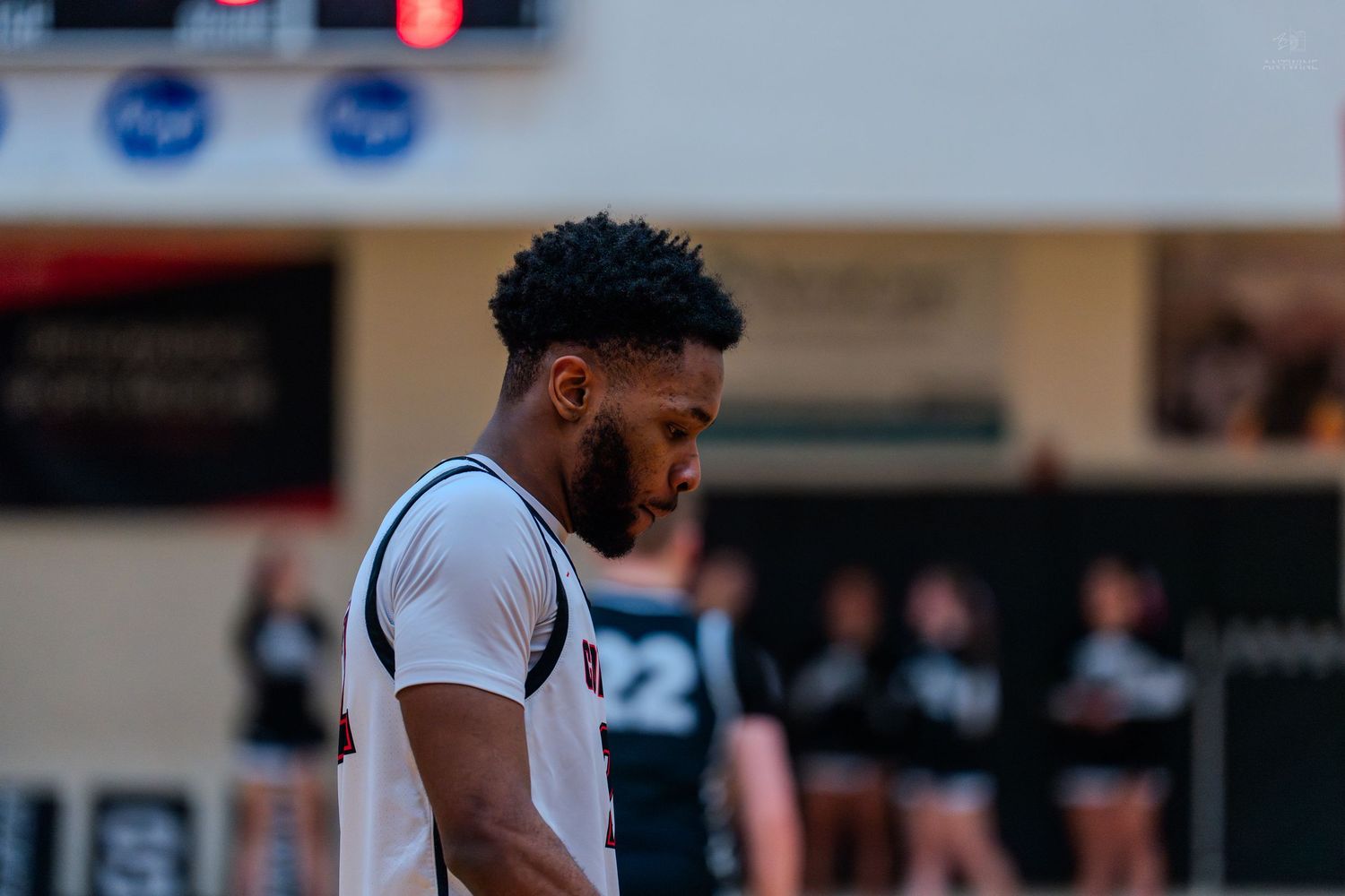 High school basketball player in white jersey focuses during game.