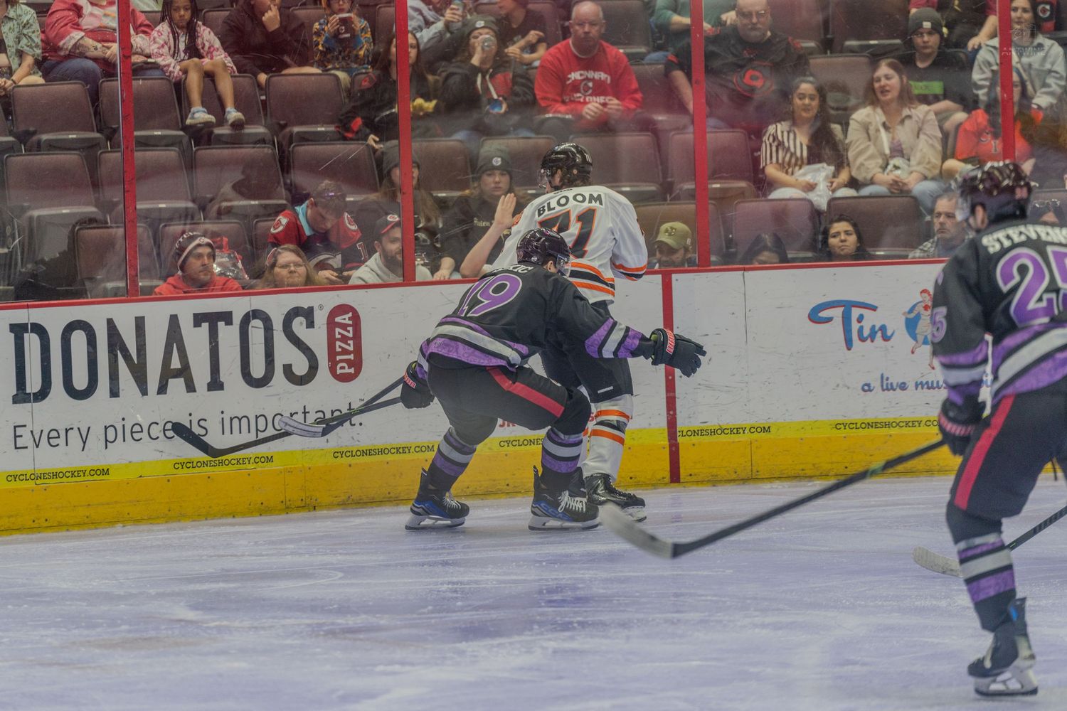 Two hockey players battle for puck possession during a competitive ice hockey match.