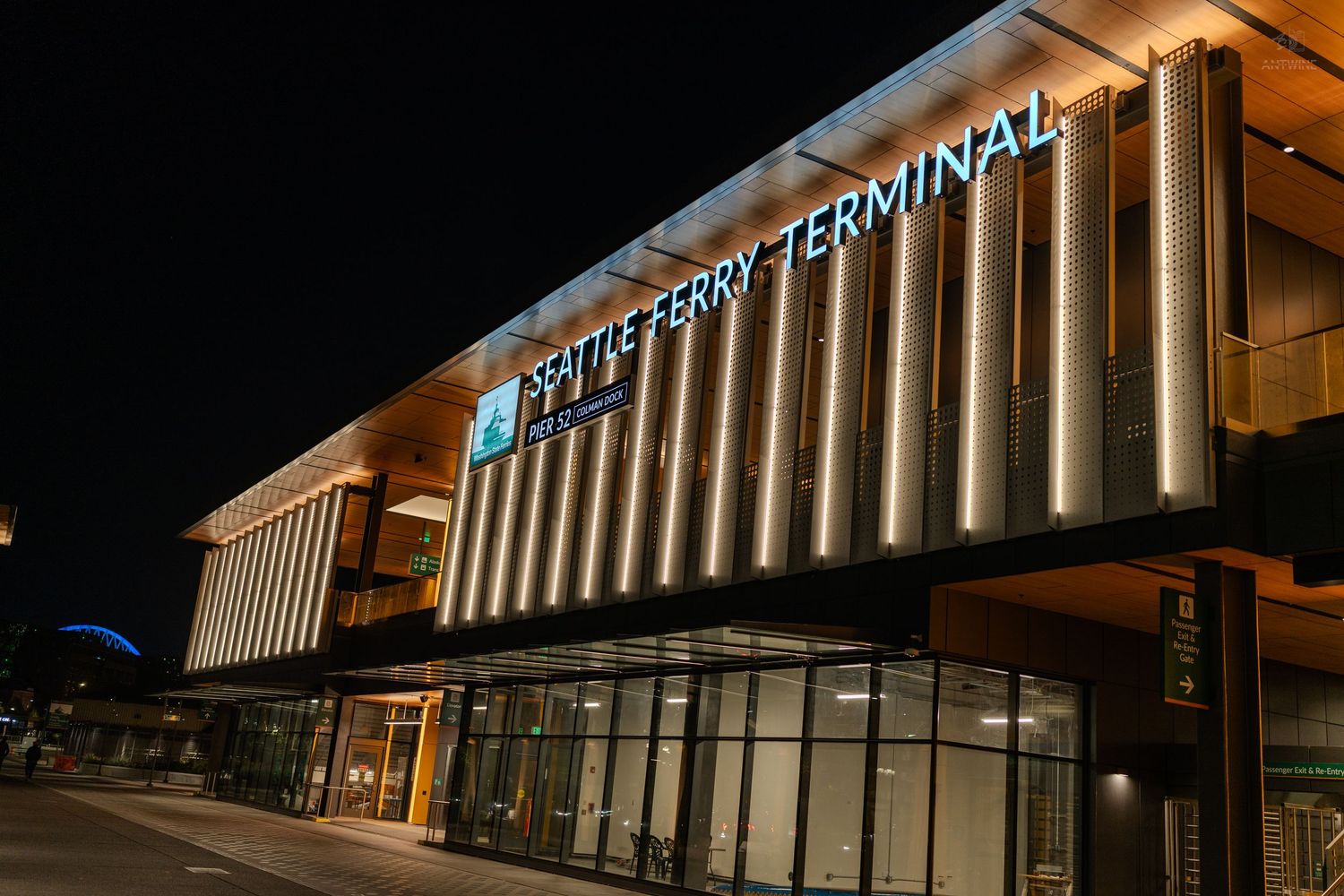 Seattle Ferry Terminal modern building exterior illuminated at night with warm architectural lighting.