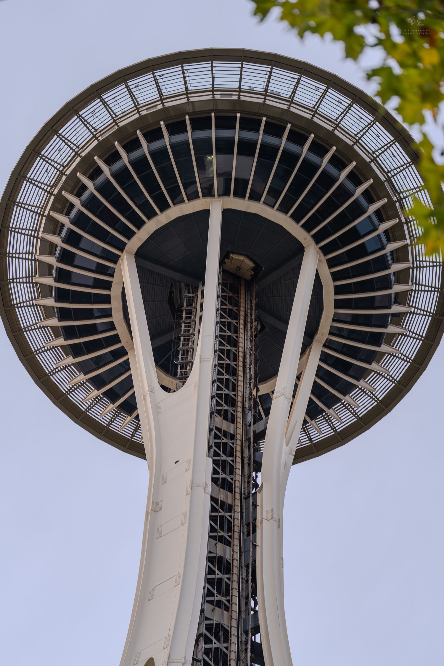 Close-up view of the iconic Space Needle tower top in Seattle, Washington, against a clear sky.