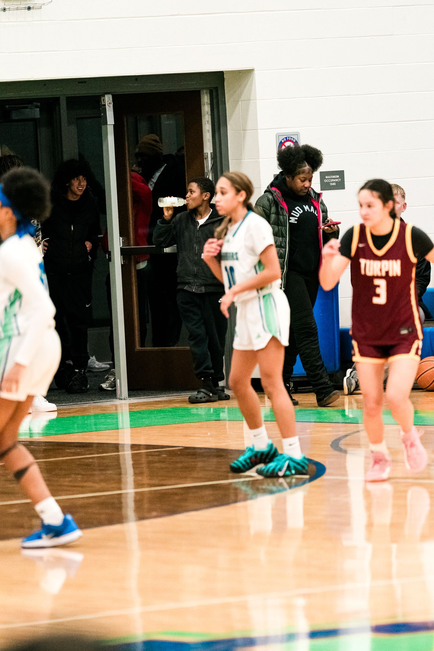 Warriors #10 player dribbles upcourt as Turpin #3 defends during girls high school basketball game.