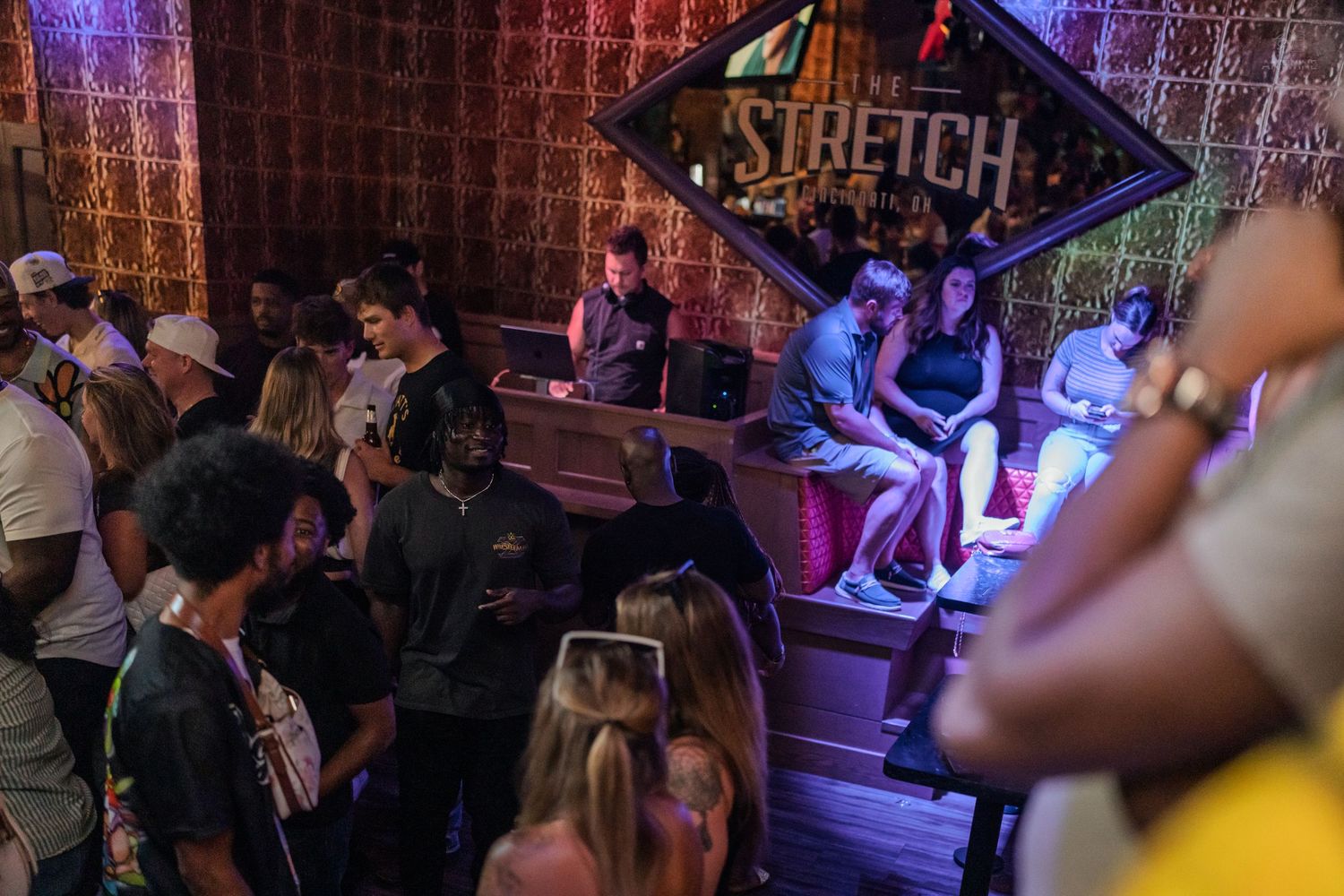 Lively crowd gathered around DJ booth at Stretch nightclub during evening event.