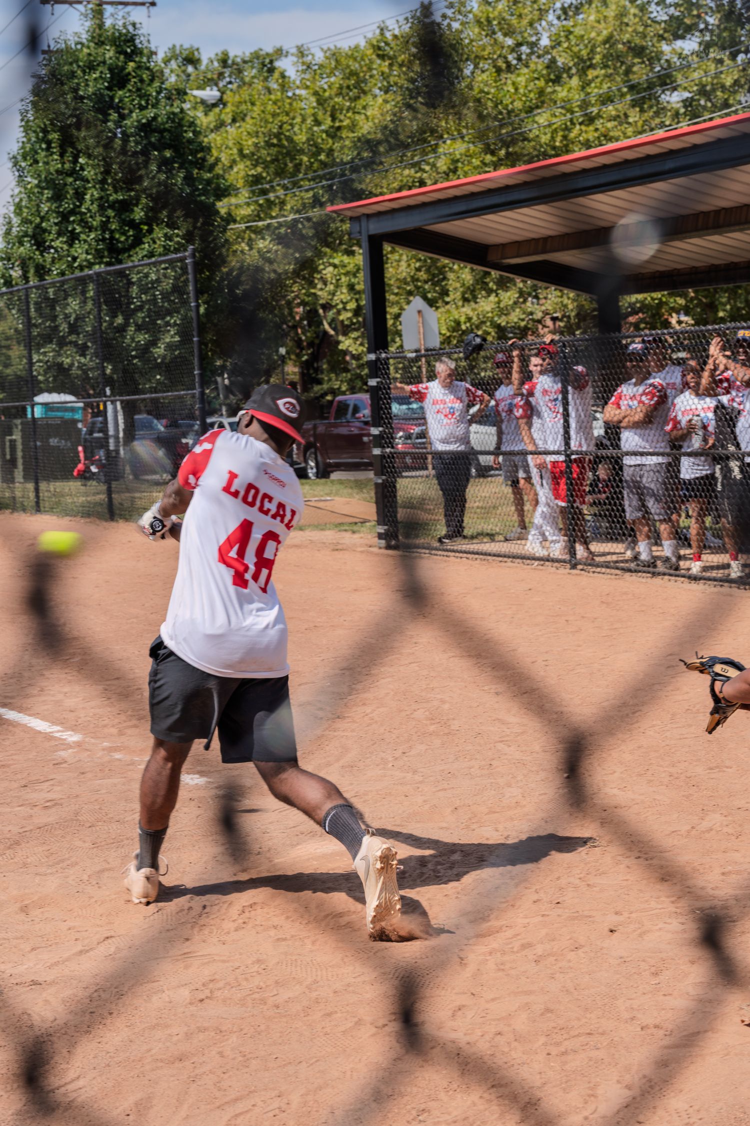 Softball player wearing Local 48 jersey swinging bat at a recreational league game.