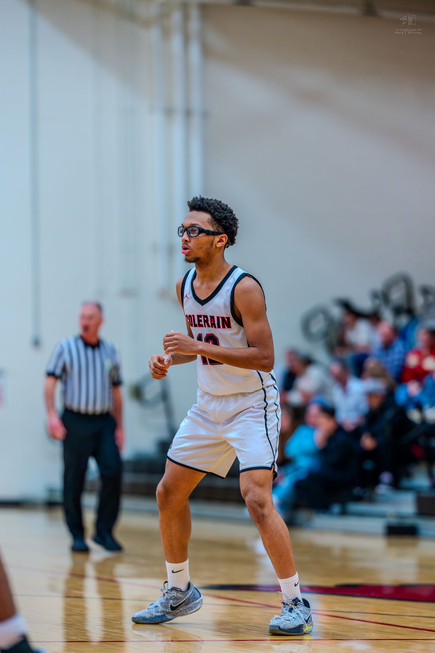 Colerain basketball player wearing glasses jogs on the court during a high school game.