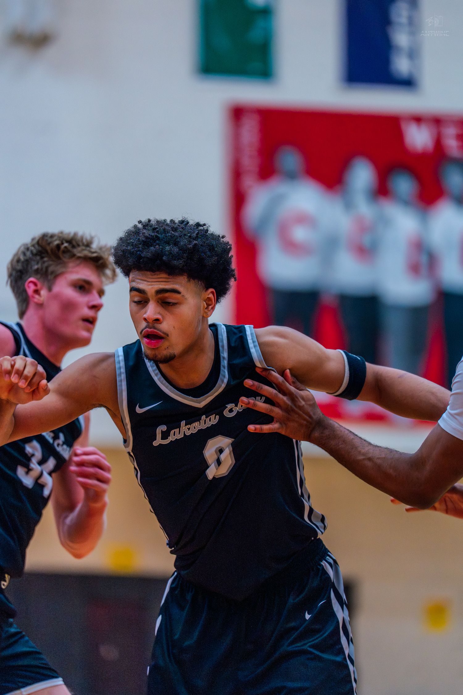 Lakota East basketball player #0 drives through defenders during a high school game.
