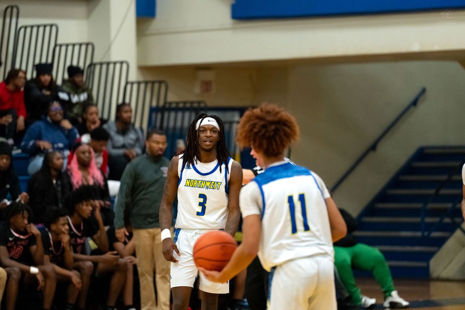 Player #3 in yellow jersey defends against opponent #11 during high school basketball game.
