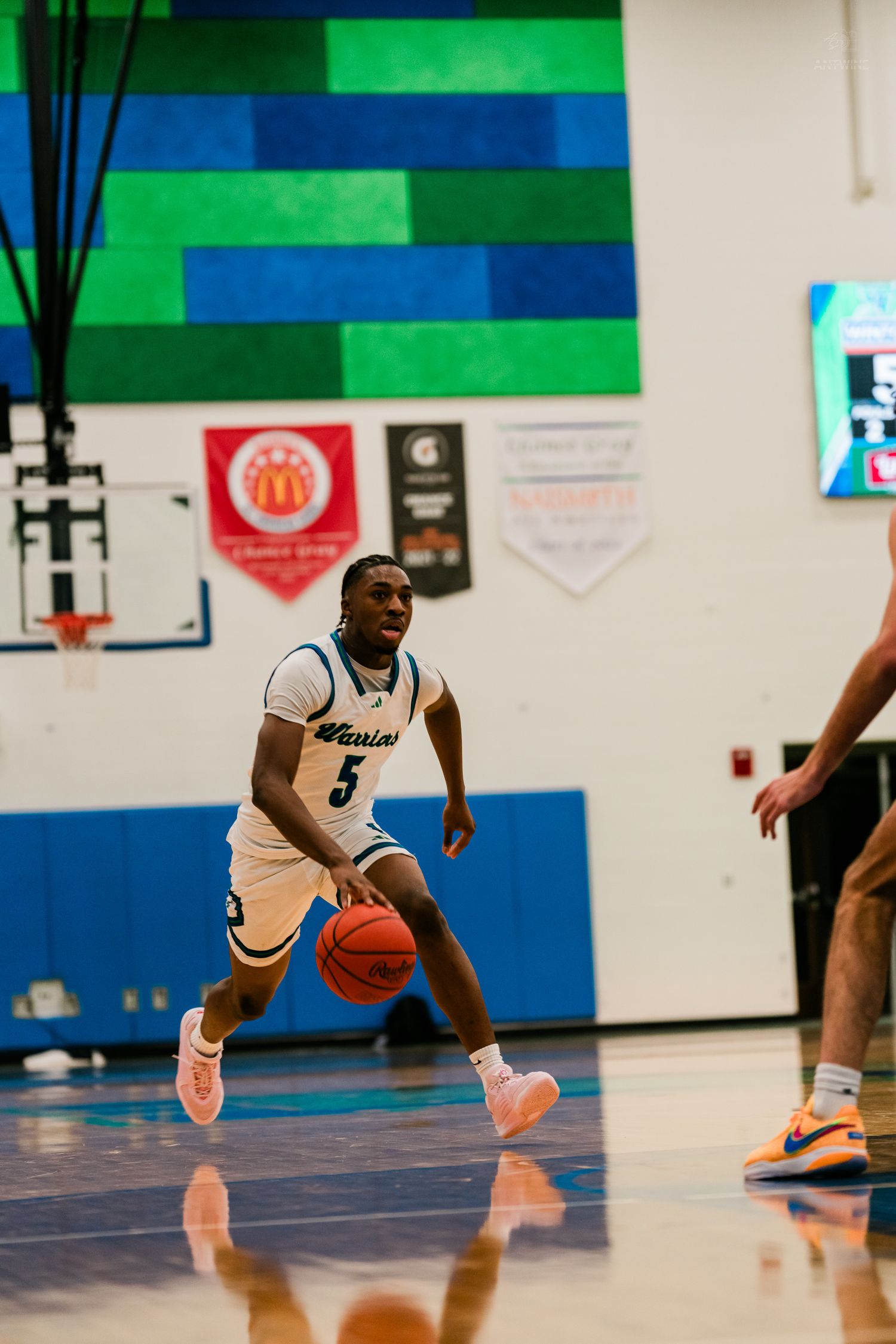 Winton Woods Warriors player #5 dribbles the ball during a home high school basketball game.