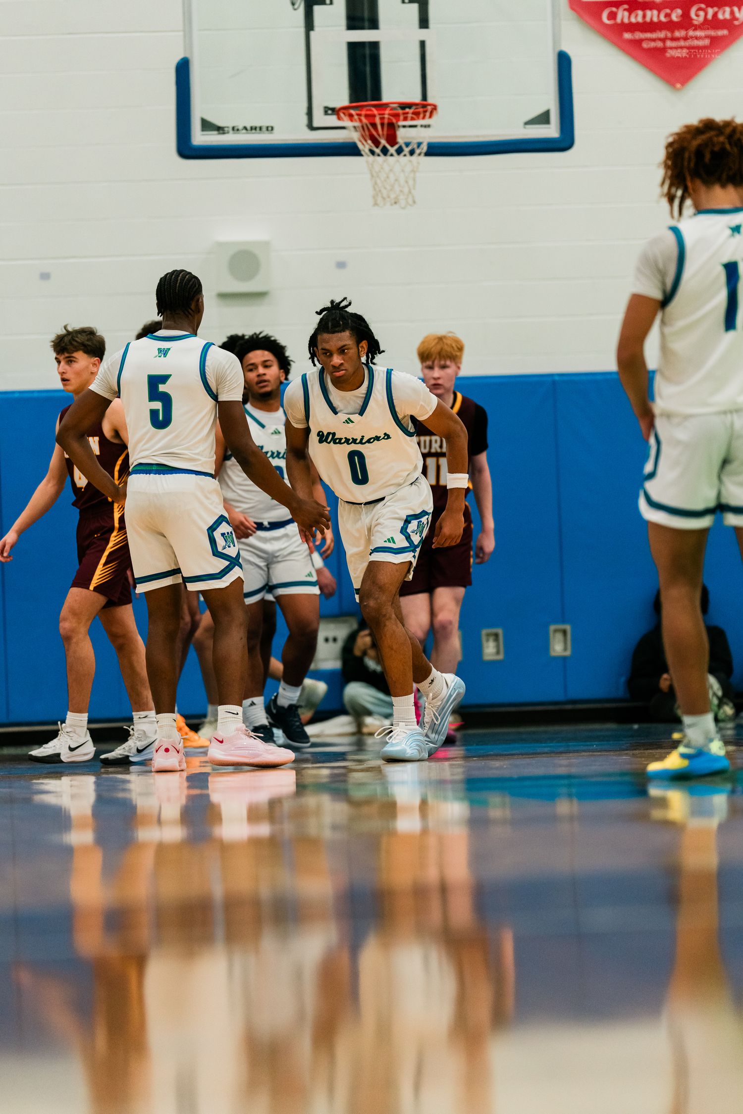 Warriors basketball player #0 celebrates with teammate #5 after a play during a home game.