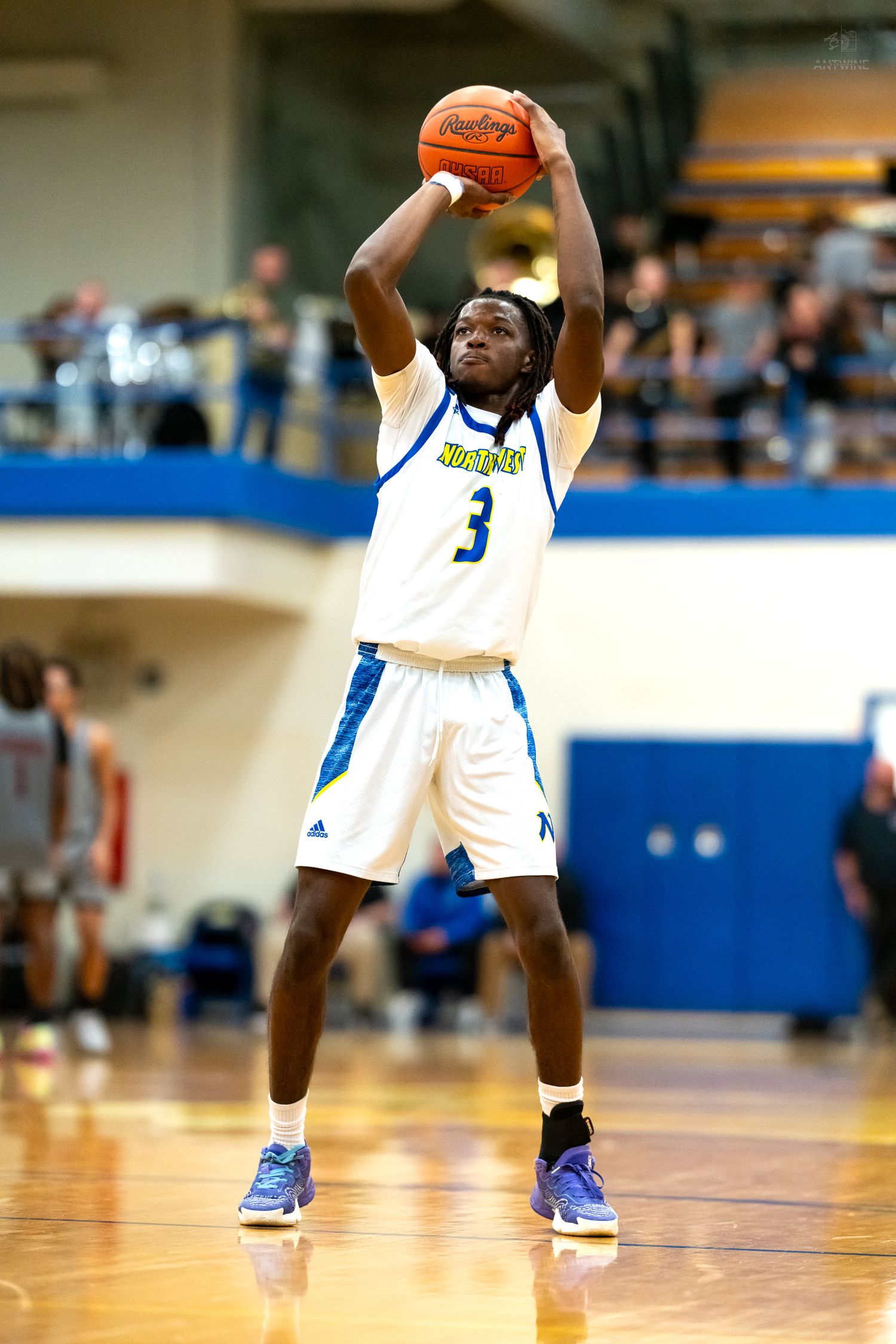 Northwest high school basketball player #3 releases a jump shot during a home basketball game.