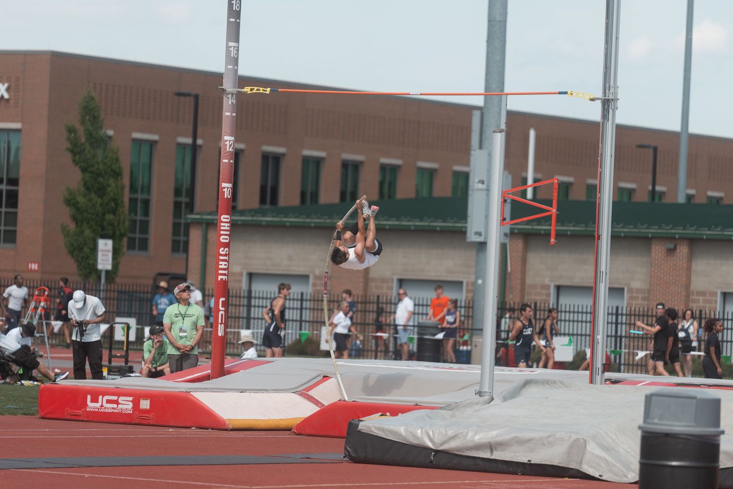 Pole vaulter soars over the bar at an Ohio State outdoor track and field competition.
