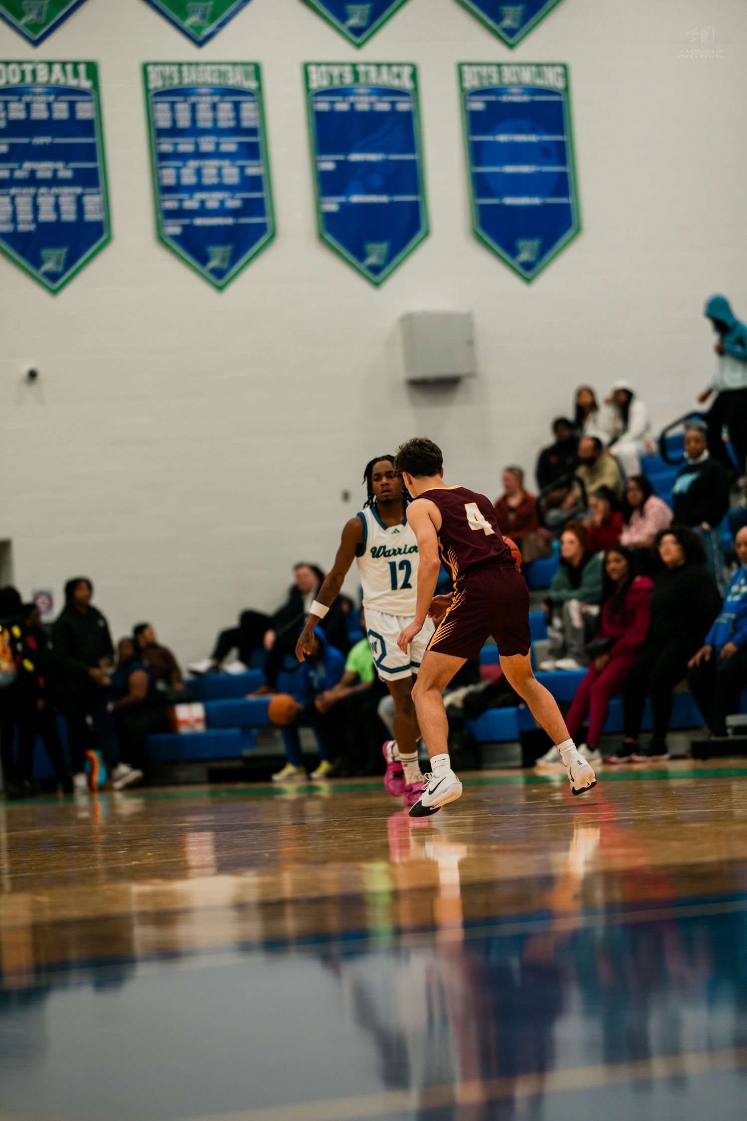 Winton Woods Warriors #12 guards a Turpin player #4 on the perimeter during a high school basketball game.