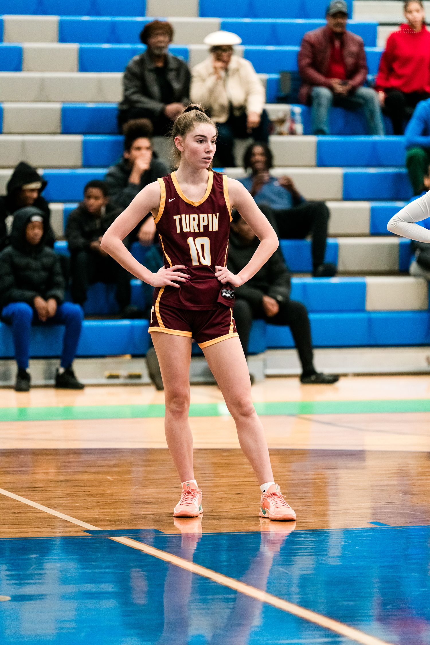 Turpin High School girls basketball player number 10 stands ready on the court during a competitive game.