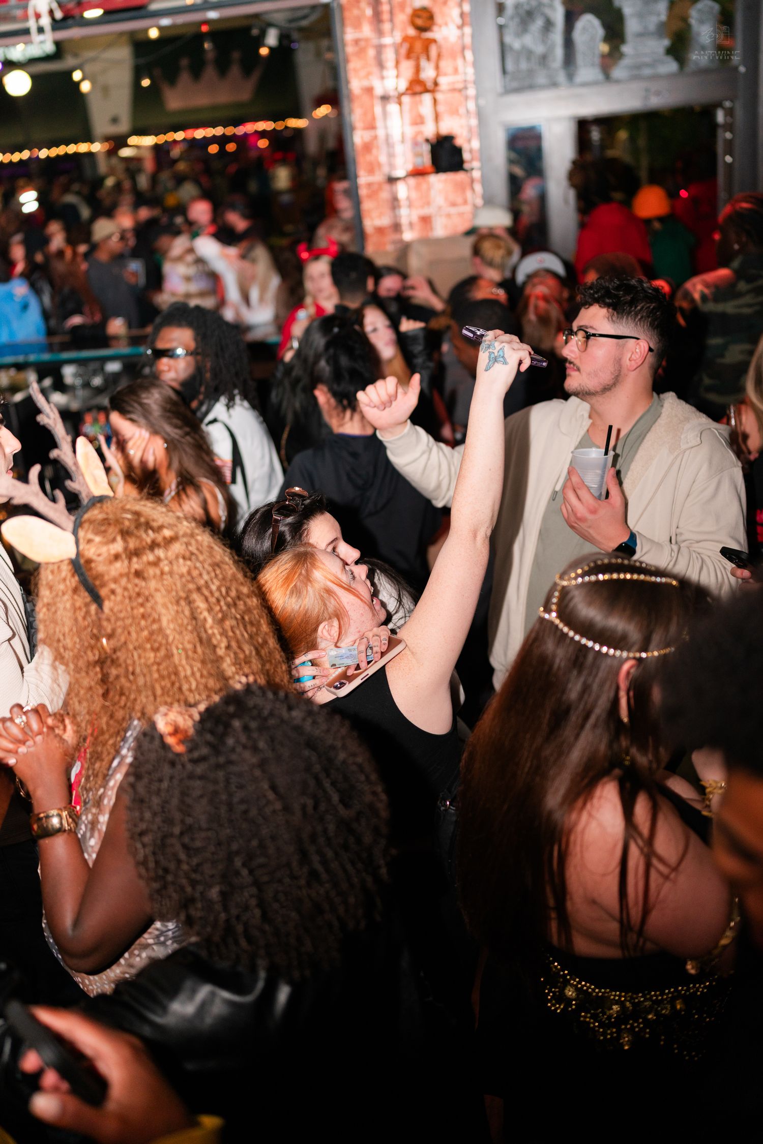 Lively Halloween party crowd with performer singing into microphone at The Stretch bar in Cincinnati OH.